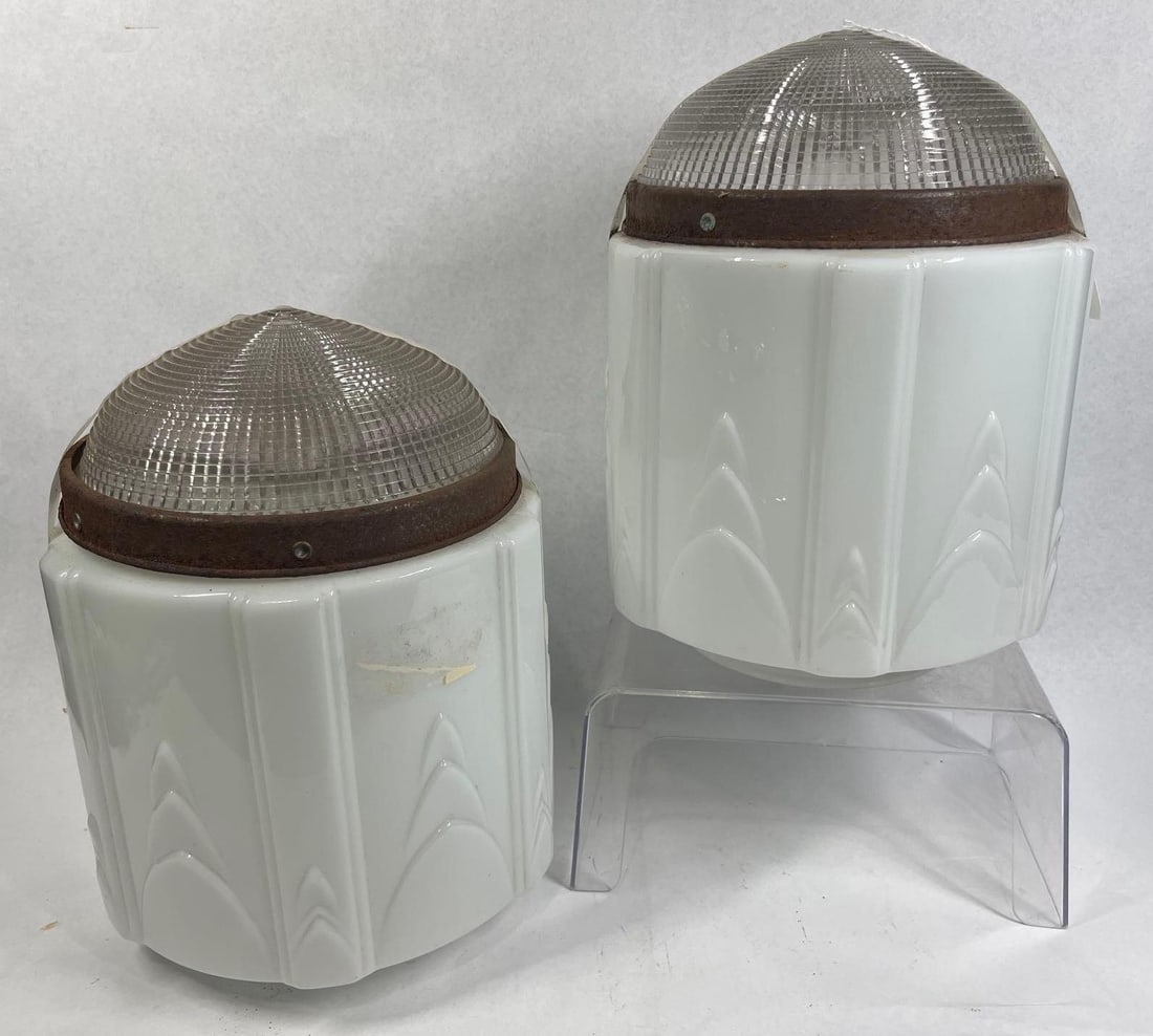 Pair Art Deco Skyscraper Light Globes: 12in talll, 9in dia. A pair of composite Art Deco style light fixture globes featuring a skyscraper design. Each globe is constructed with a lower body of opaque white milk glass decorated with