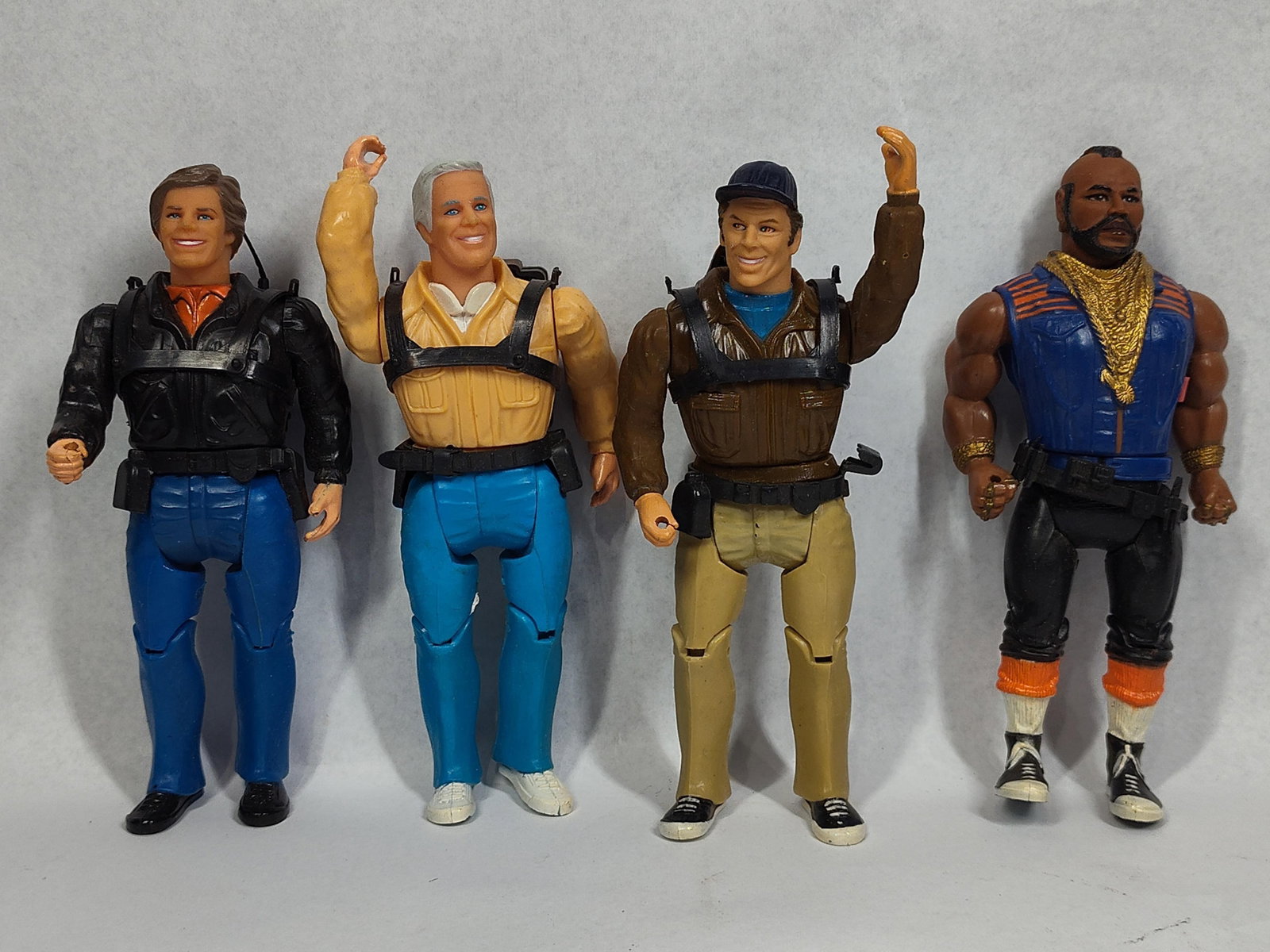 Set 4 The A-Team Action Figures: This set comprises four molded plastic action figures representing the primary cast of the 1980s television series The A-Team. The collection includes Colonel John Hannibal Smith, Lieutenant