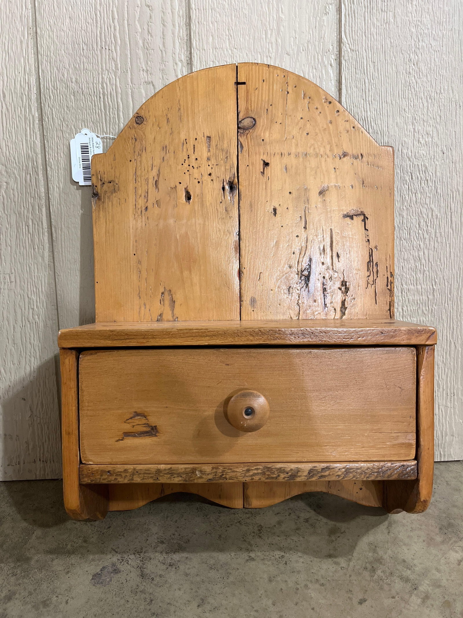 Schuler Pine Primitive Shelf w/ Drawer: 33x16x6 This wall-mounted primitive style hanging shelf was manufactured by Country Furniture by Schuler in Janesville, Wisconsin. The piece is constructed from pine and features a tall, arched backbo