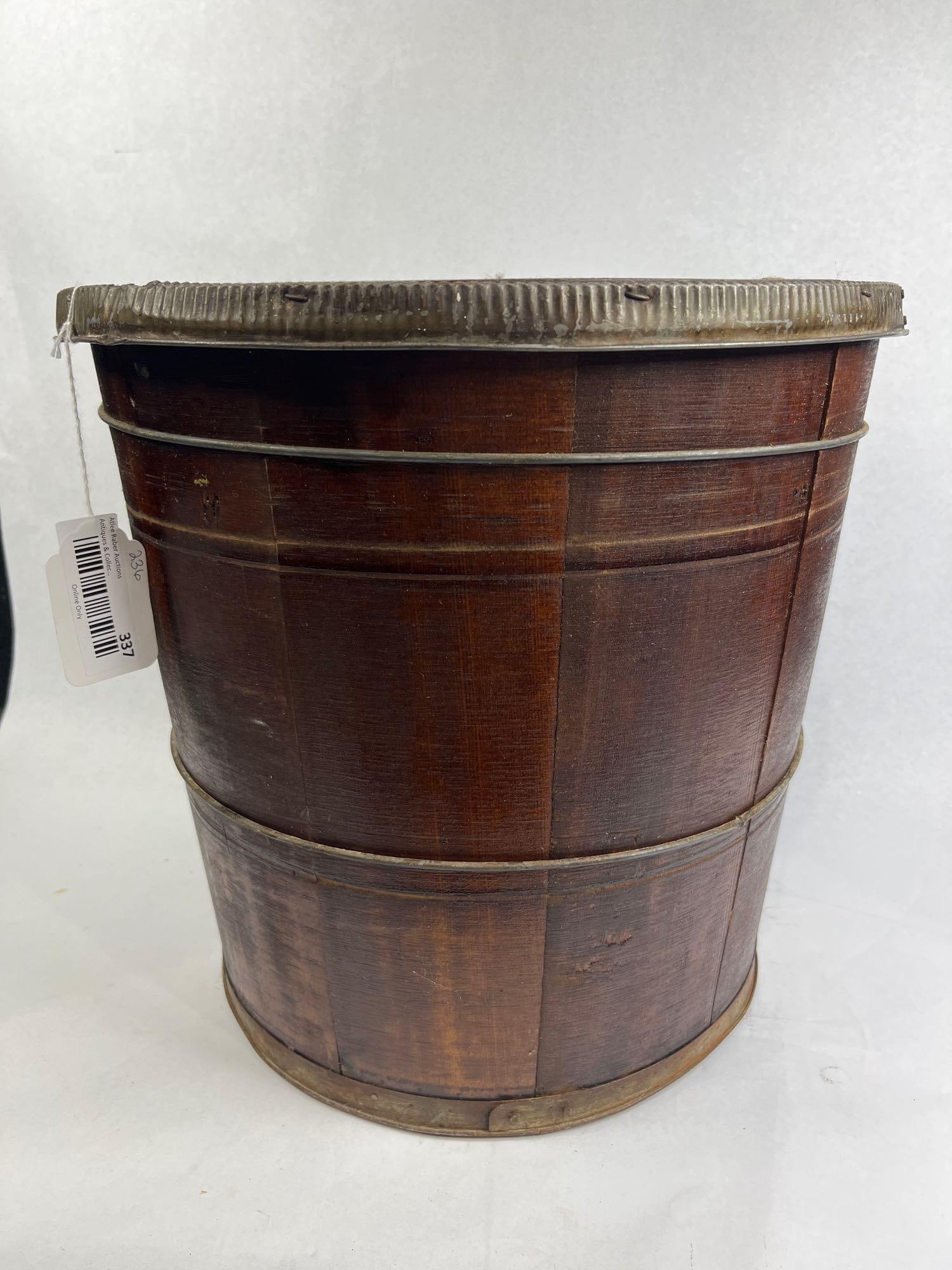Stave Wood Container w/ Lid & Metal Rim: 15x15 This antique container is of wooden stave construction, featuring a fitted flat lid and metal reinforcements. The piece is built with vertical wooden staves finished in a dark stain, held in