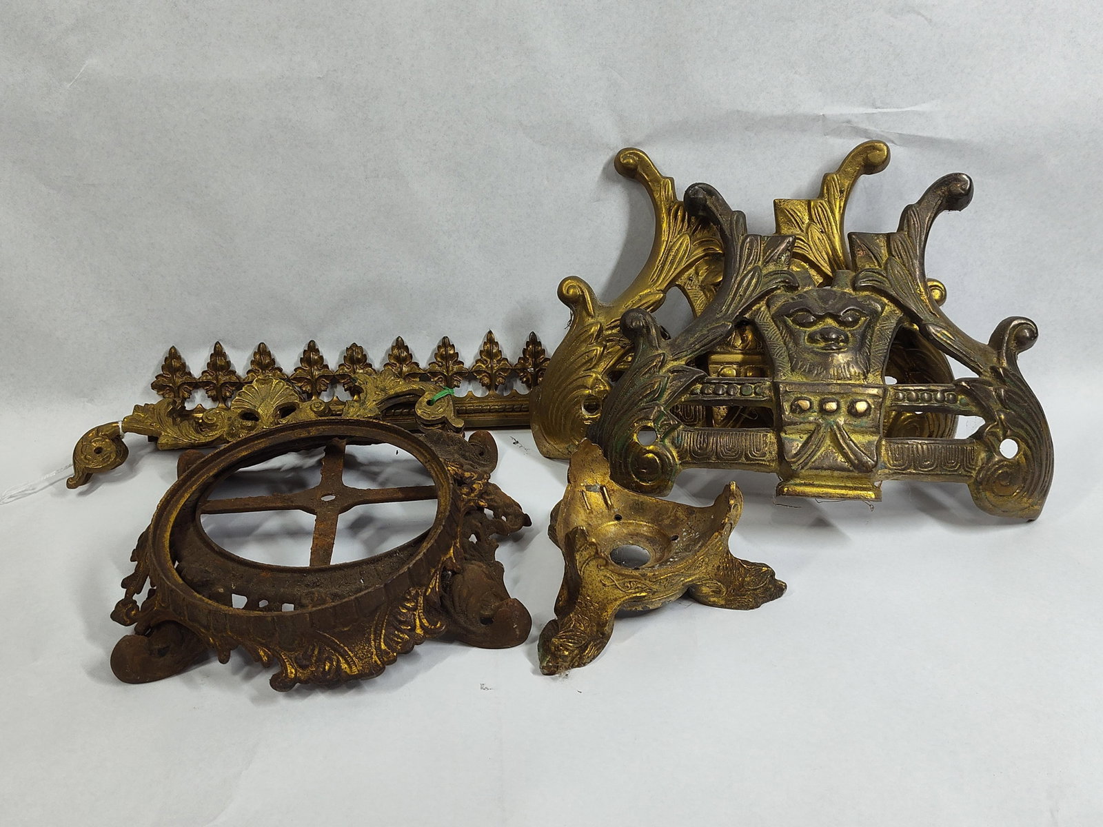 Bradley & Hubbard Style Lamp Components: An assortment of antique cast metal decorative and functional components, likely originating from late 19th or early 20th-century parlor lamps and furniture. The group includes matching cast mounts fe
