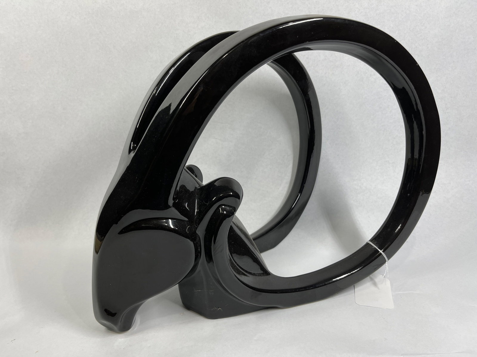 Jaru Style Black Ceramic Ram Sculpture: 16x12x8 This is a modernist stylized ram or bighorn sheep sculpture in the style of Jaru Pottery. The piece is constructed of molded ceramic with a uniform high-gloss black glaze. The form features a 