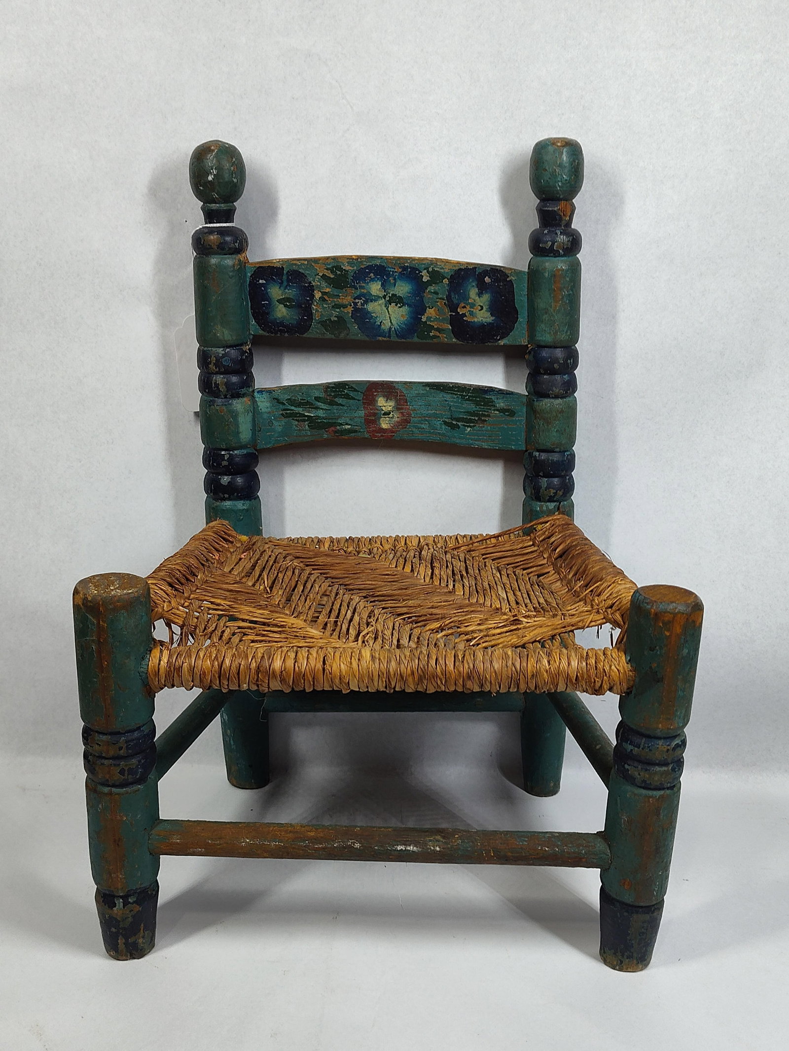Mexican Folk Art Painted Wood Child: 13x9x18 This vintage Mexican folk art child's ladder-back side chair is characteristic of mid-20th century rustic furniture production. The chair features a wooden frame with ring-turned posts and leg