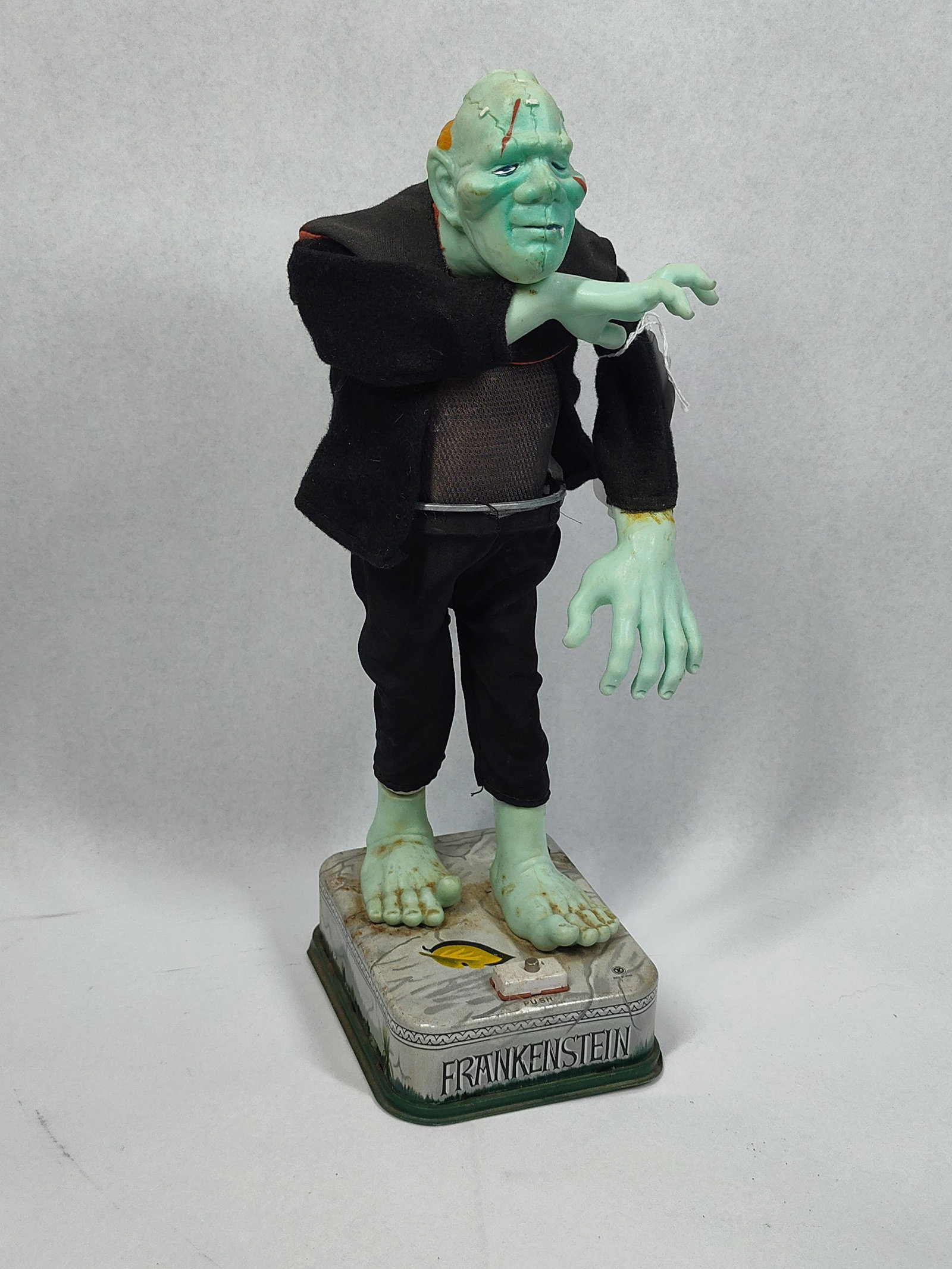Nomura Rosko Blushing Frankenstein Toy: 13.5in tall This vintage battery operated character toy depicts Frankensteins Monster and was manufactured by Nomura T.N. and imported by Rosko in the 1960s. The toy consists of a lithographed tin bas