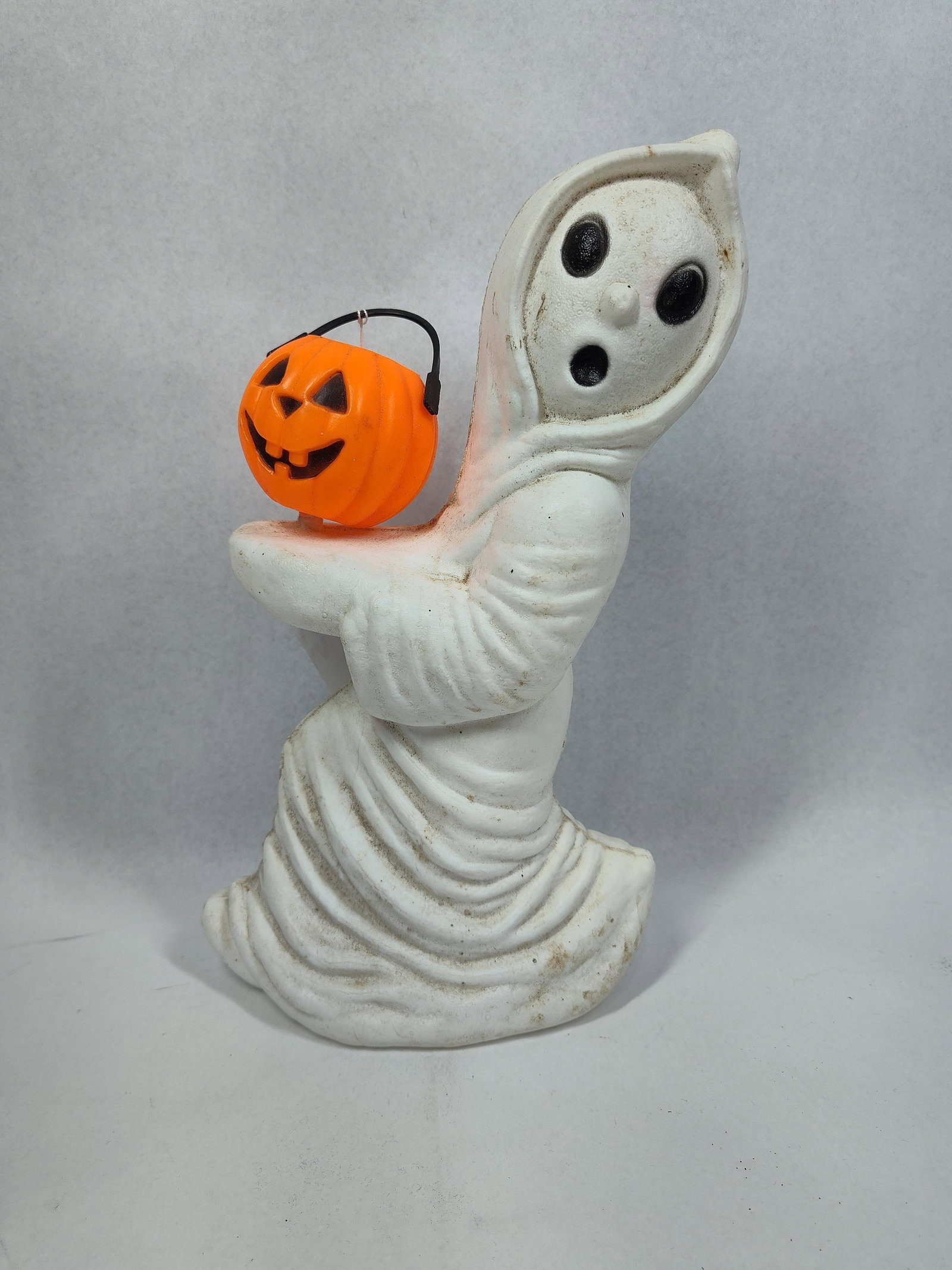 Blow-Mold Ghost w/ Jack-o-Lantern: 13in tall This vintage blow-mold Halloween decoration depicts a ghost holding a jack-o-lantern. Based on the distinctive mold design, the figure is attributed to General Foam, although no manufacturer