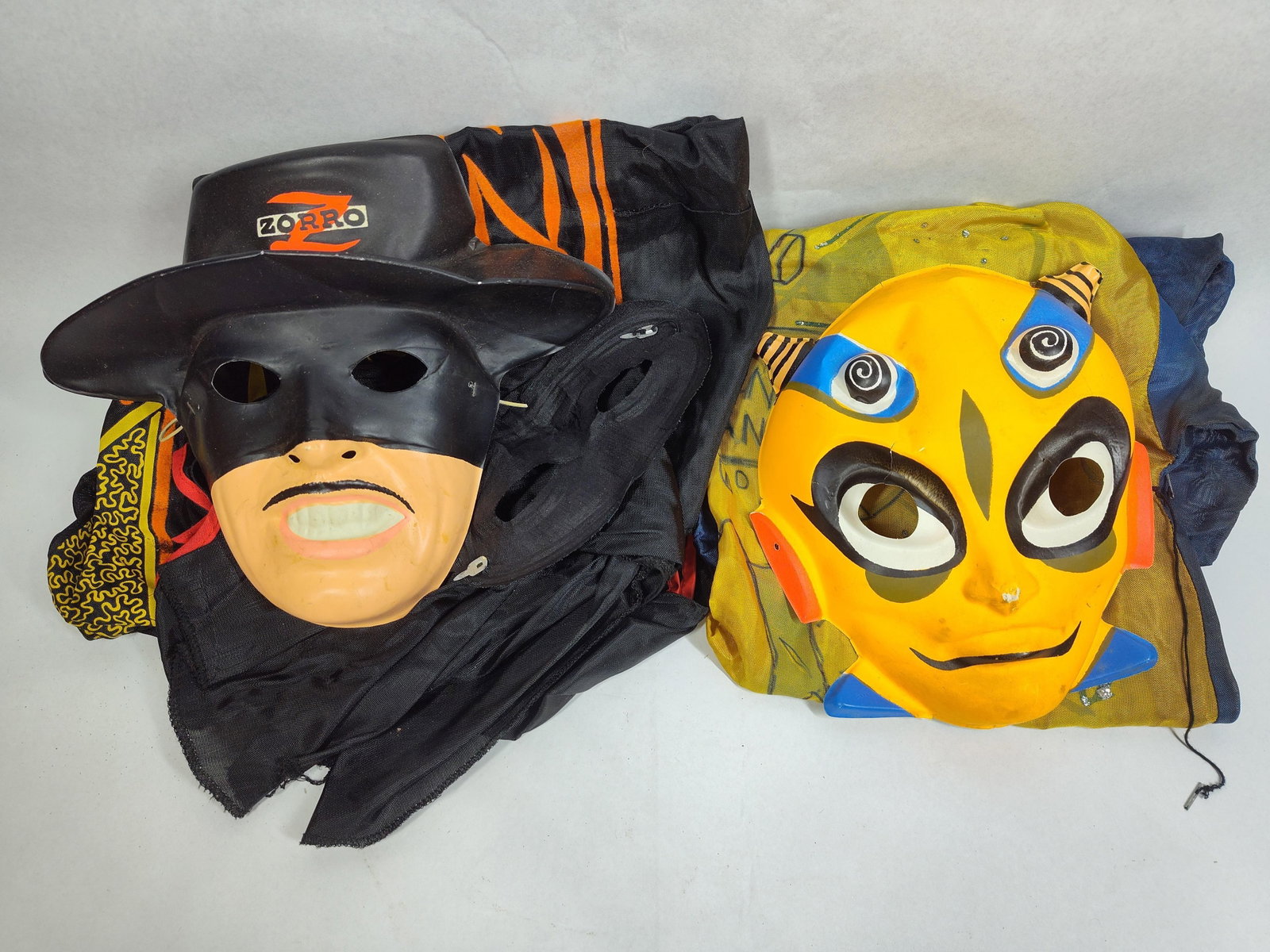 Pair Zorro & Moon Man Costumes: This lot features two mid-20th-century children's Halloween costumes, depicting the characters Zorro and Moon Man. These items are characteristic of the style produced by manufacturers such as