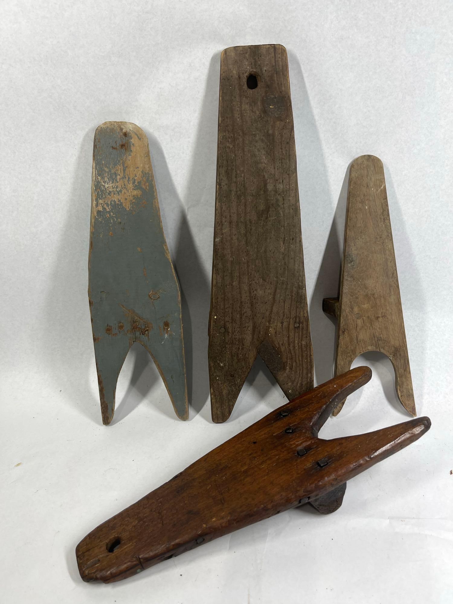 4 Antique Primitive Wooden Boot Jacks: A group of four antique and vintage wooden boot jacks designed to assist in the removal of footwear. Each piece is constructed from a tapered wooden board with a heel notch at the wide end and a