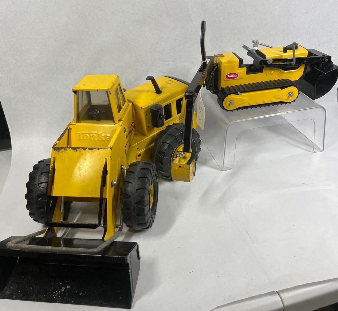 Pair Tonka Steel Construction Vehicles: This lot features two vintage Tonka construction toys manufactured from pressed steel and plastic. The first item is a Mighty Tonka front-end wheel loader. It is constructed primarily of yellow