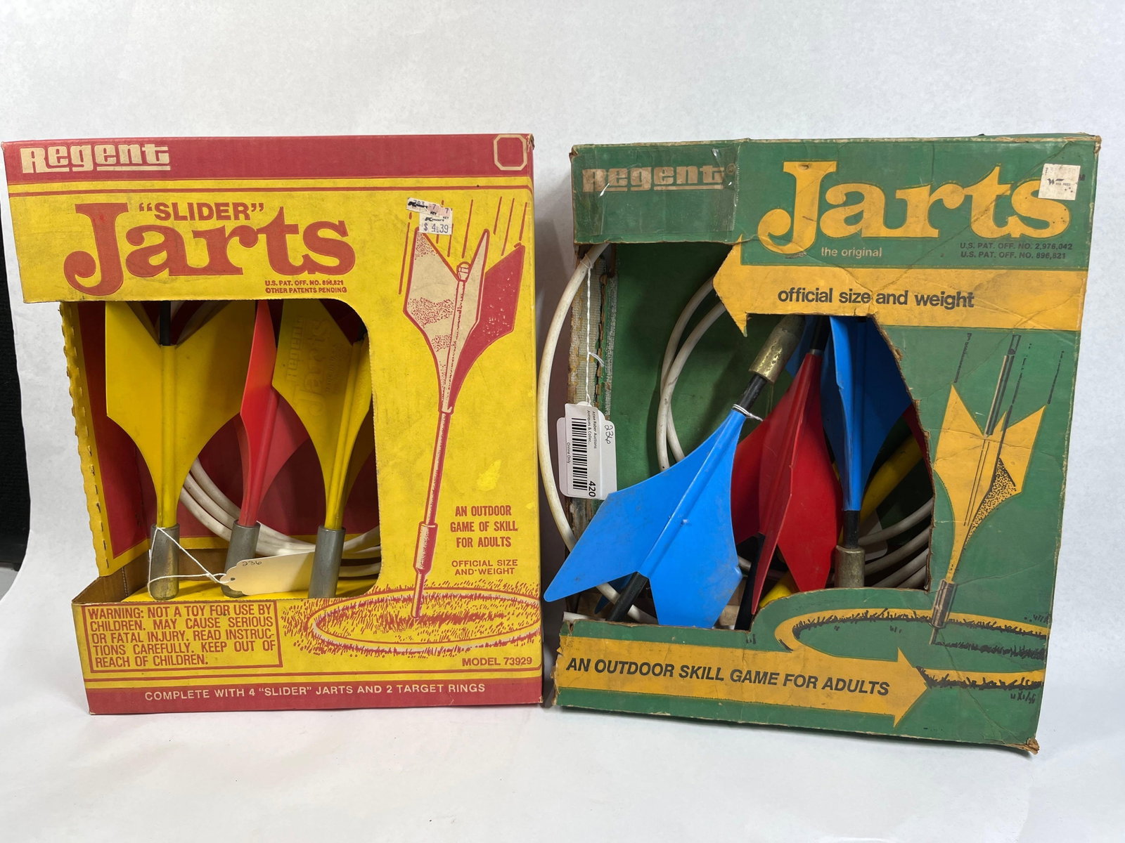 Two Regent Sports Jarts Lawn Sets: A pair of vintage outdoor lawn dart game sets produced by Regent Sports Corporation of Hauppauge, New York. The first set is the Slider Jarts model 73929, also identified by part number 01-73927 on th