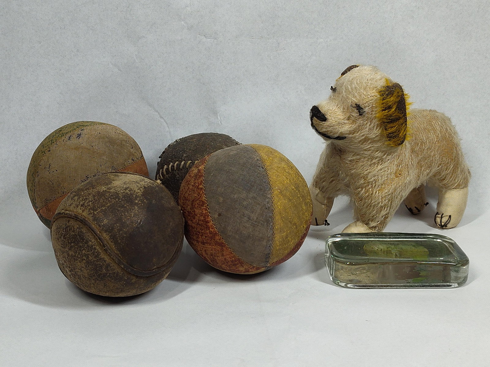Antique Toy Balls, Dog & Paperweight: This group consists of several vintage playthings and a souvenir item. Included are two antique leather softballs featuring traditional out-seam construction with prominent hand-stitched seams.