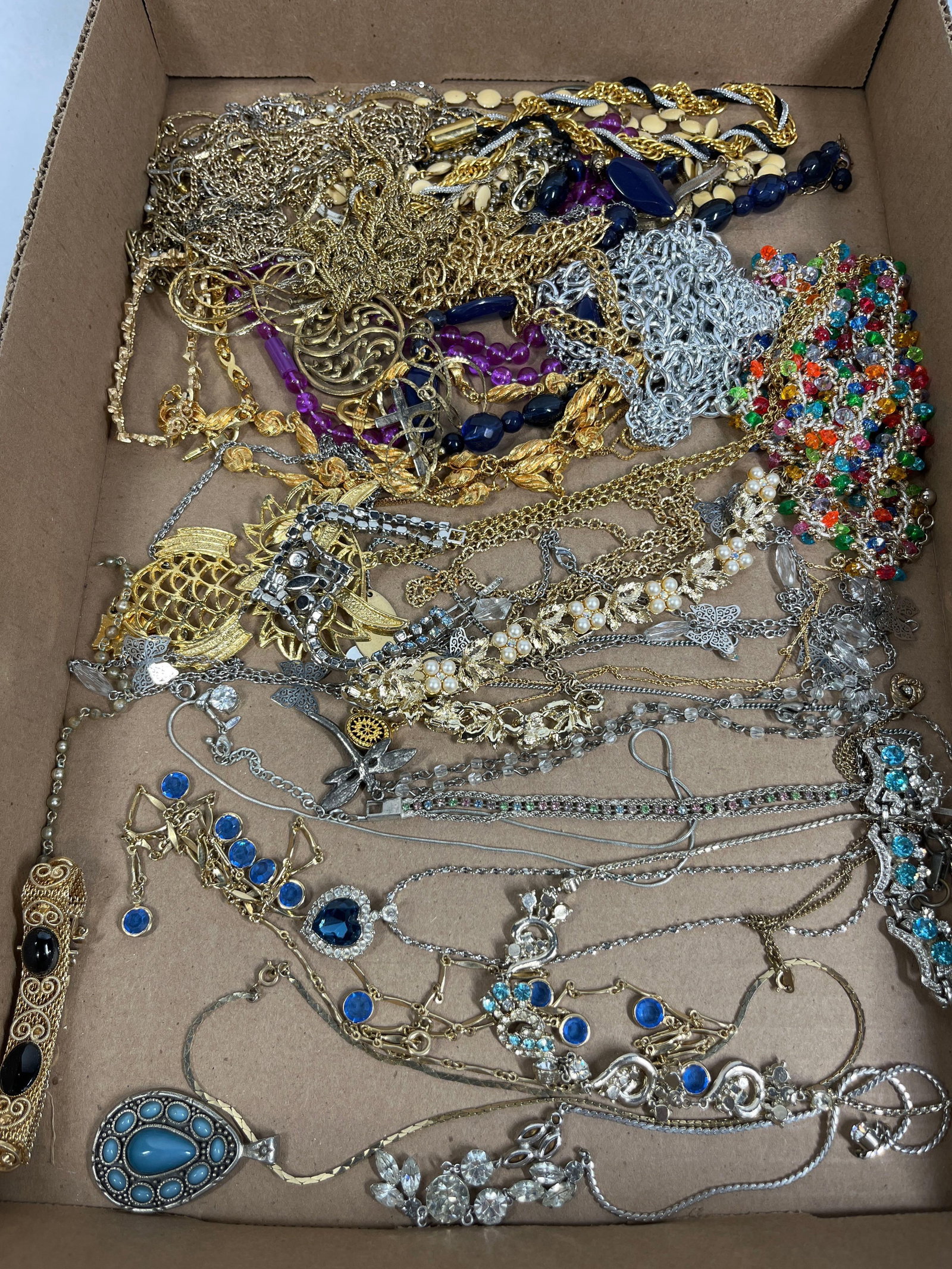 Costume Jewelry Necklaces &: An assortment of costume jewelry comprising various necklaces, pendants, and chains in a bulk lot. The collection features gold-tone and silver-tone base metals with multiple chain types including rop