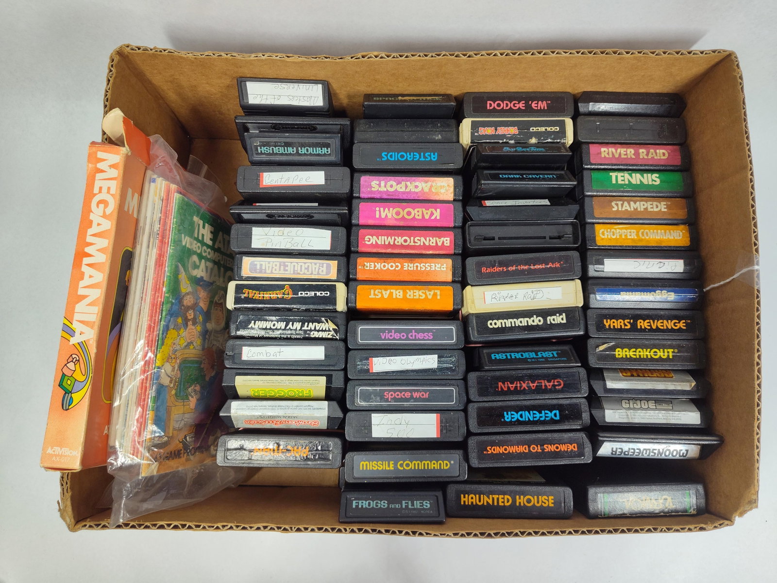 Set Atari 2600 Cartridges & Manuals: A large collection of video game cartridges and printed documentation for the Atari 2600 Video Computer System (VCS). The group includes cartridges from the original manufacturer, Atari, alongside