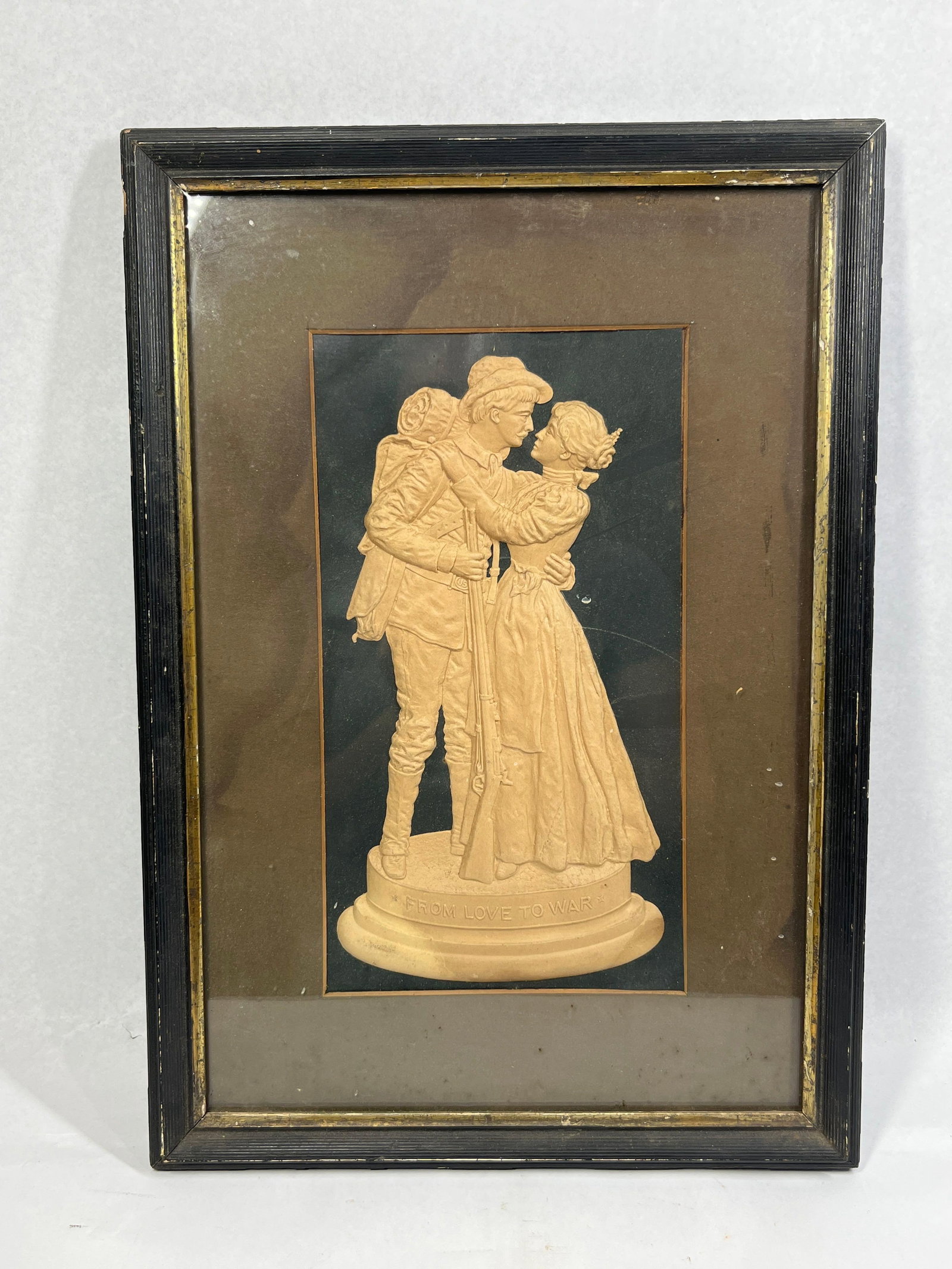 American School 19C. Love to War Relief: 18x12 This framed relief plaque is cast from a buff-colored plaster or composite material, featuring a soldier and a woman in a parting embrace. The soldier is portrayed in military attire consistent
