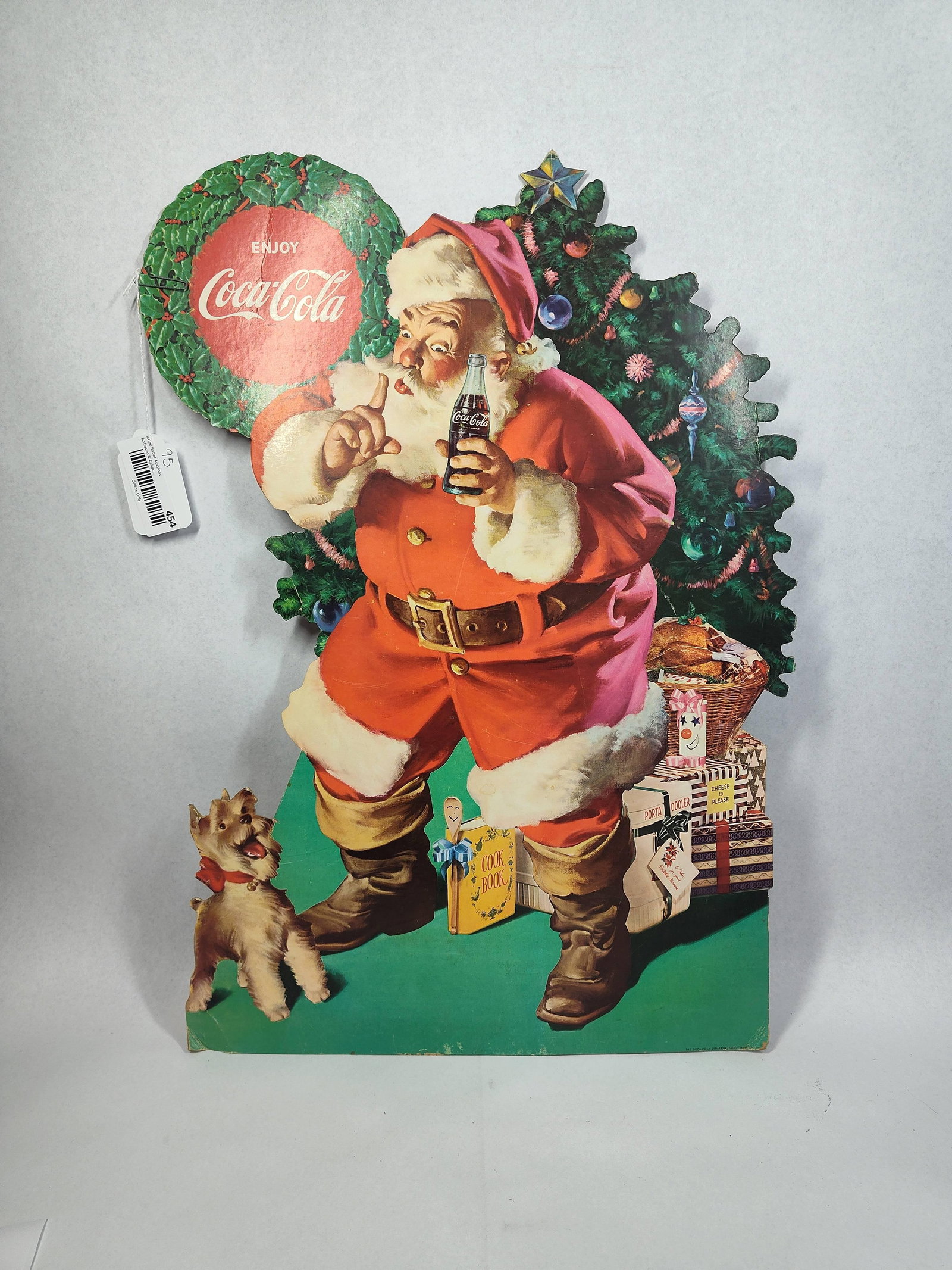 Mid-C. Coca-Cola Santa & Dog Standee: 24x16 This vintage advertising display is a cardboard easel standee produced for The Coca-Cola Company. The illustration features the iconic Haddon Sundblom-style Santa Claus in his traditional red