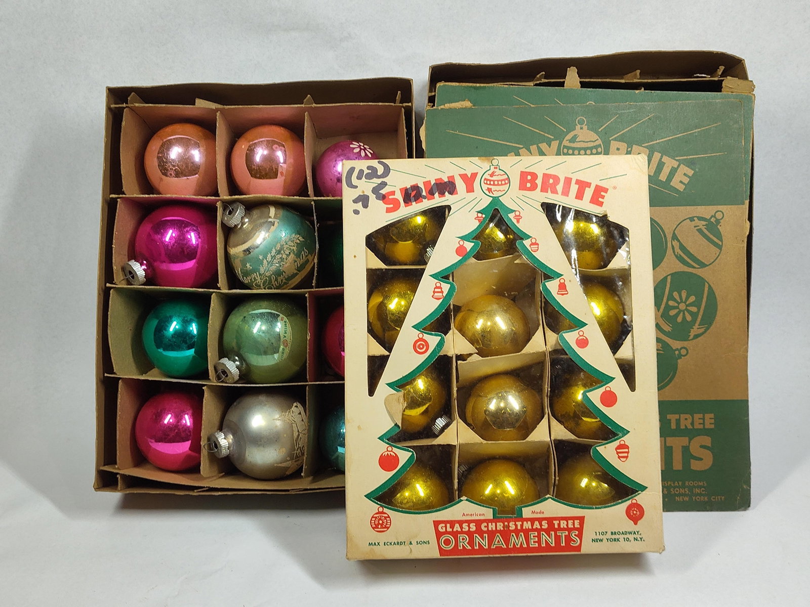 36 Shiny Brite Ornaments w/ Boxes: This lot features 36 vintage glass Christmas ornaments manufactured by Max Eckardt & Sons under the Shiny Brite brand. The ornaments are constructed from hand-blown glass and exhibit a variety of