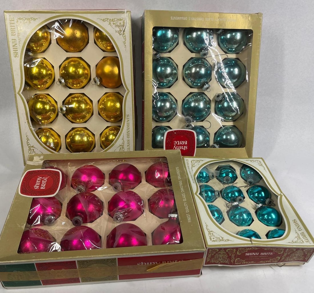 Shiny Brite Glass Ornaments & Boxes: A collection of vintage glass Christmas ornaments produced by Shiny Brite. This assortment includes four original cardboard display boxes containing spherical glass baubles in metallic shades of