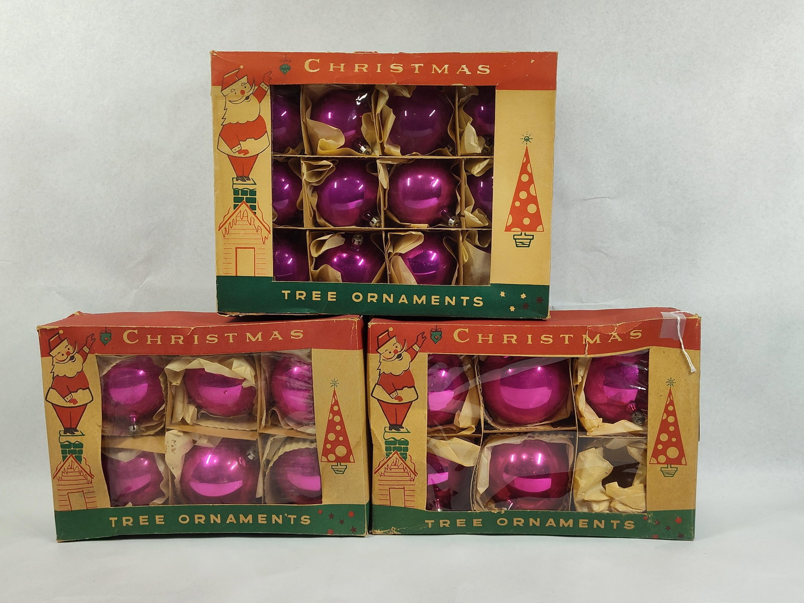3 Boxes Hot Pink Glass Tree Ornaments: A collection of three original boxes containing vintage spherical glass Christmas tree ornaments finished in a vibrant magenta or hot pink glaze. The assortment consists of one larger box containing