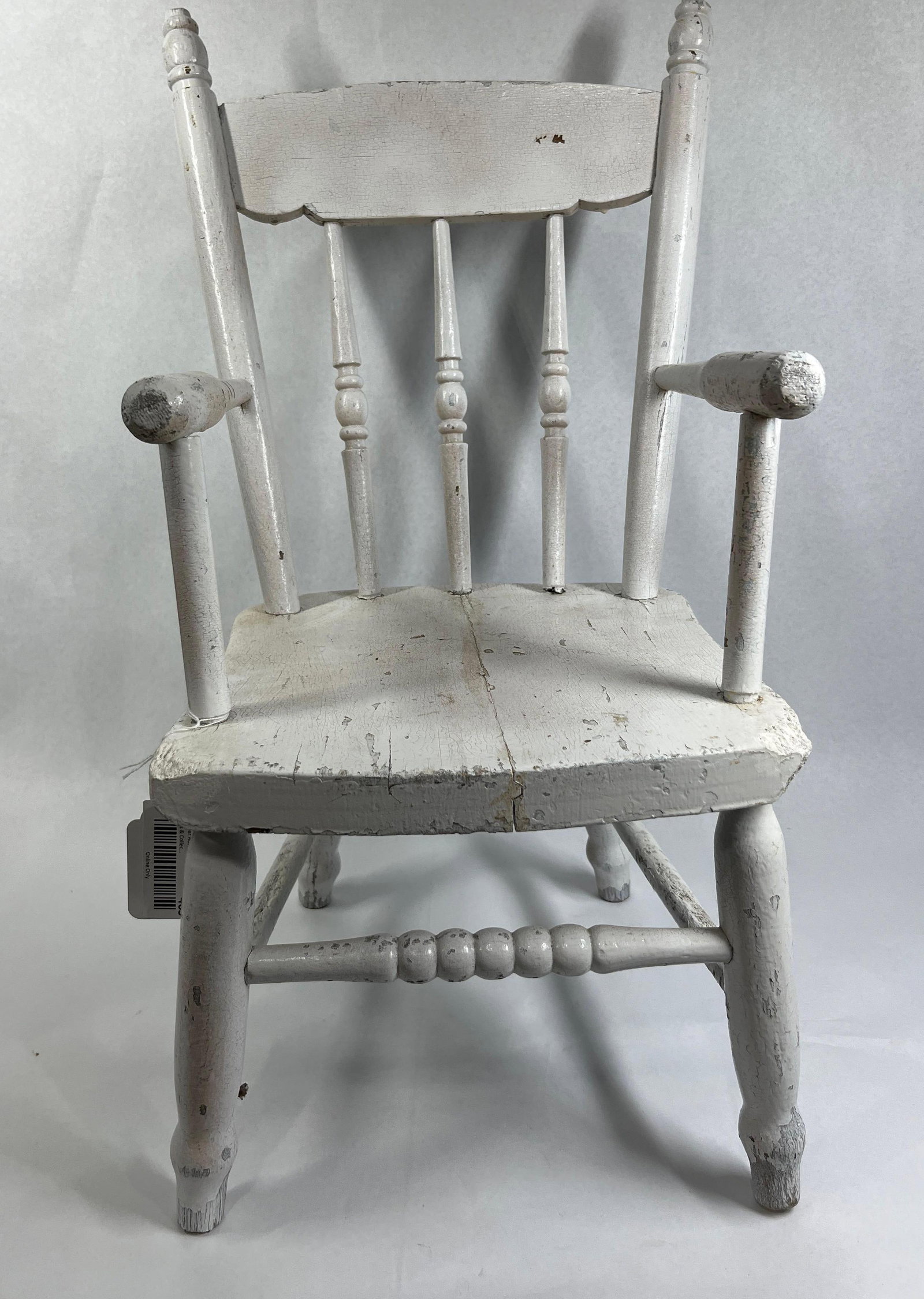 Child's White Spindle-Back Armchair: 25x14x12 This is a single child-sized wooden armchair featuring a primitive farmhouse or spindle-back design. The construction includes a two-plank slab seat and a slightly reclined backrest. The