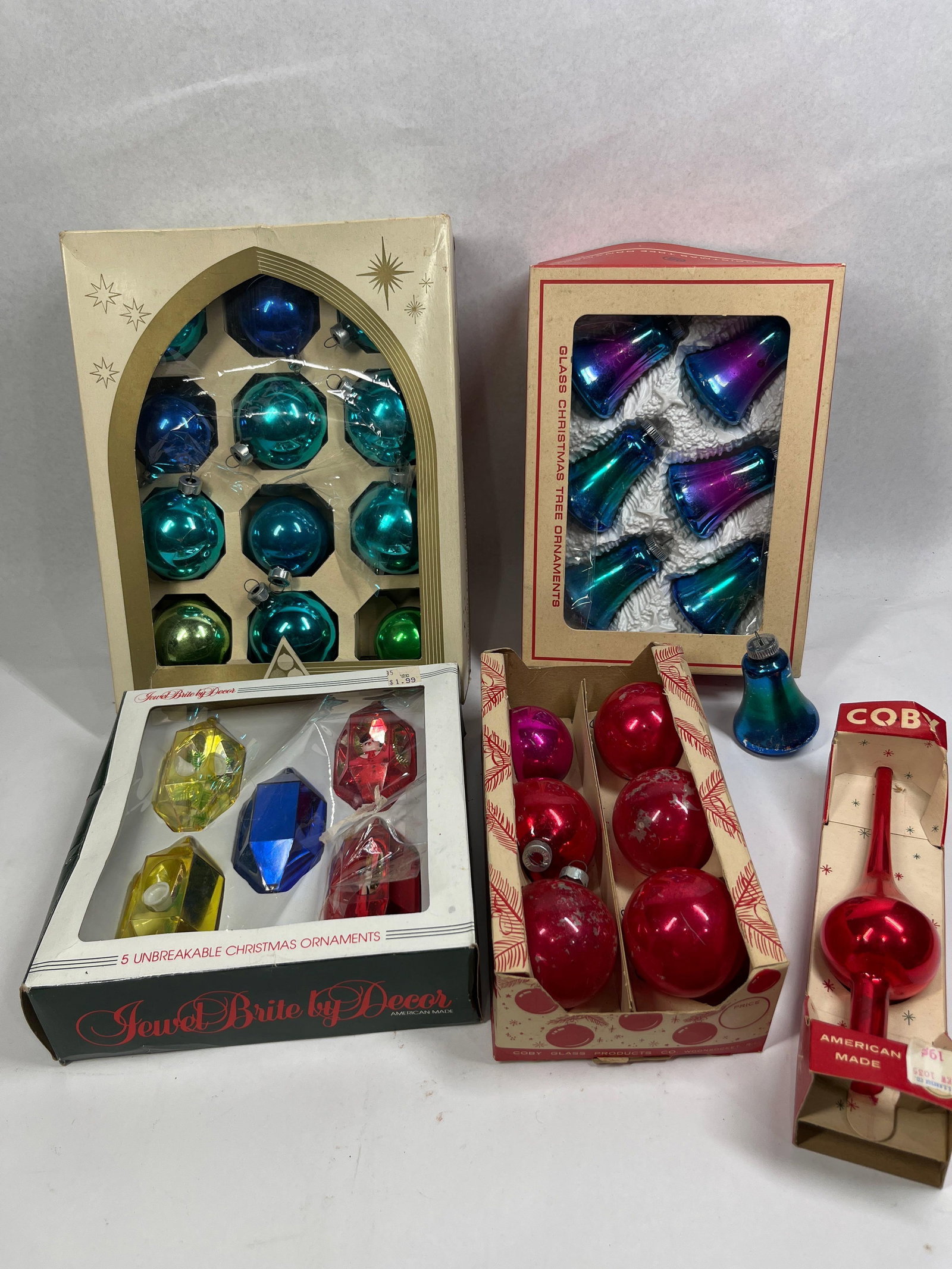 Coby, Delta & Jewel Brite Ornaments: An assortment of mid-century Christmas ornaments featuring various makers and styles. The collection includes a box of Delta Ornaments containing round glass spheres in shades of blue, teal, and green