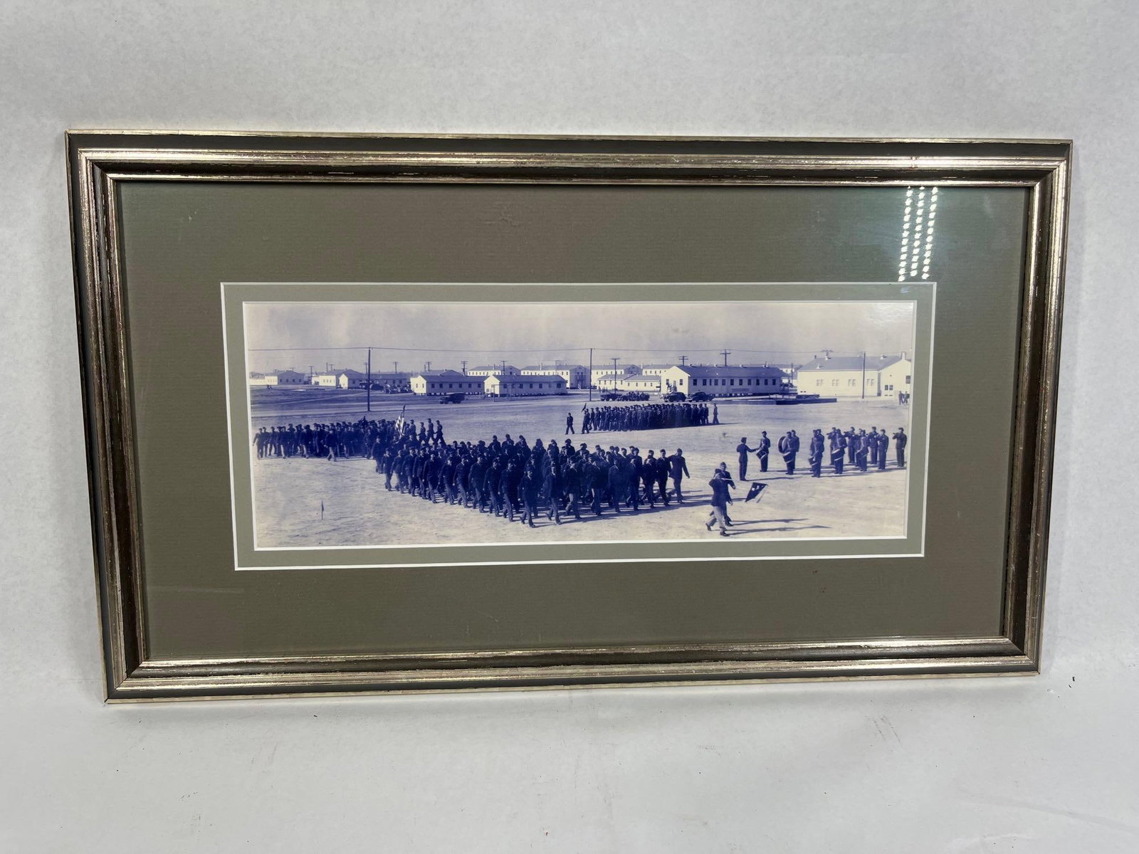 Panoramic Silver Gelatin Military Photo: 20x11.5 This panoramic silver gelatin print depicts a large-scale military formation parading across a dirt field. The scene captures several units of soldiers in uniform marching, with one unit