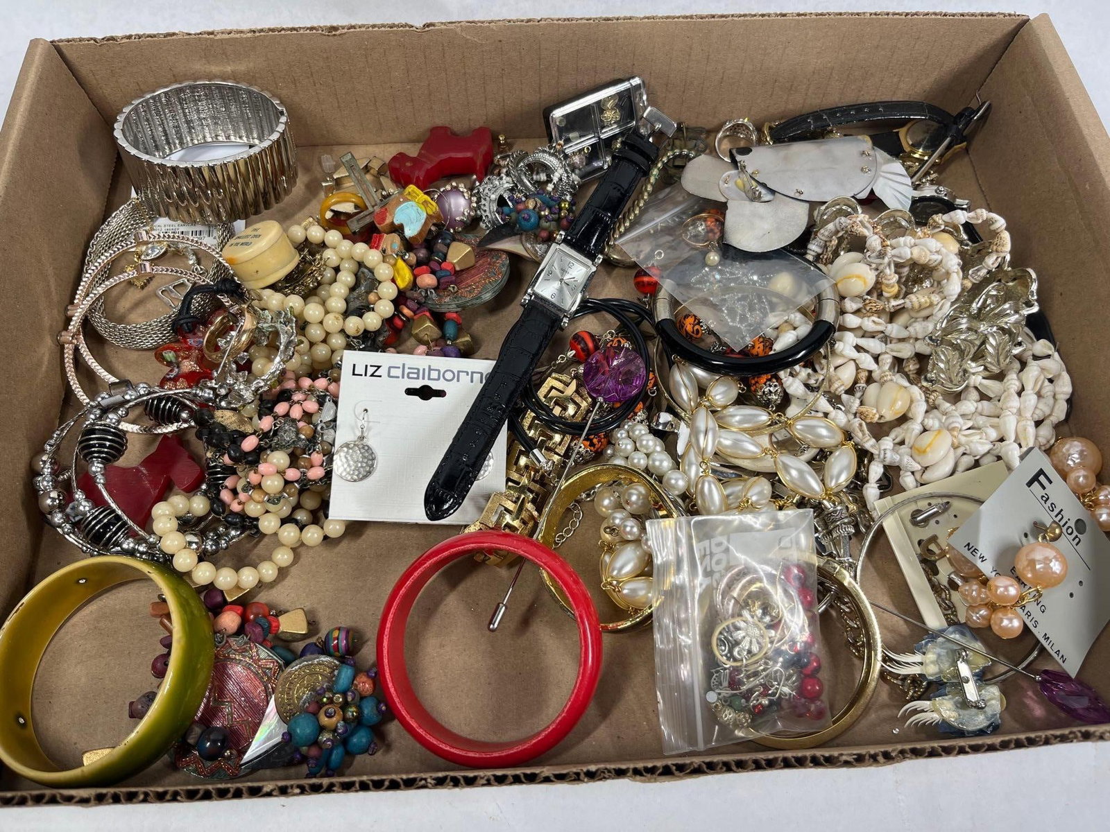 Costume Jewelry, Watches & Novelties: A diverse collection of costume jewelry, accessories, and novelty items. The lot features two ladies' wristwatches: a rectangular silver-tone Gossip watch with a black textured faux-leather strap 