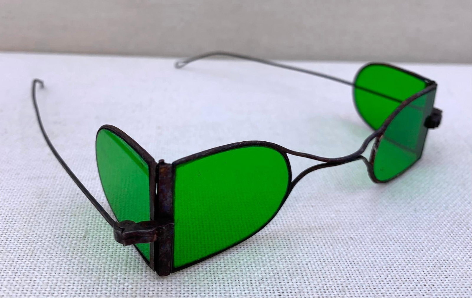 Antique Victorian Emerald Green Glass Hinged Folding Double D Sunglass Spectacles: Metal wire frame, 4 emerald green D shaped lenses, working hinges, light surface oxidation to areas of the metal, 4 3/4" width.