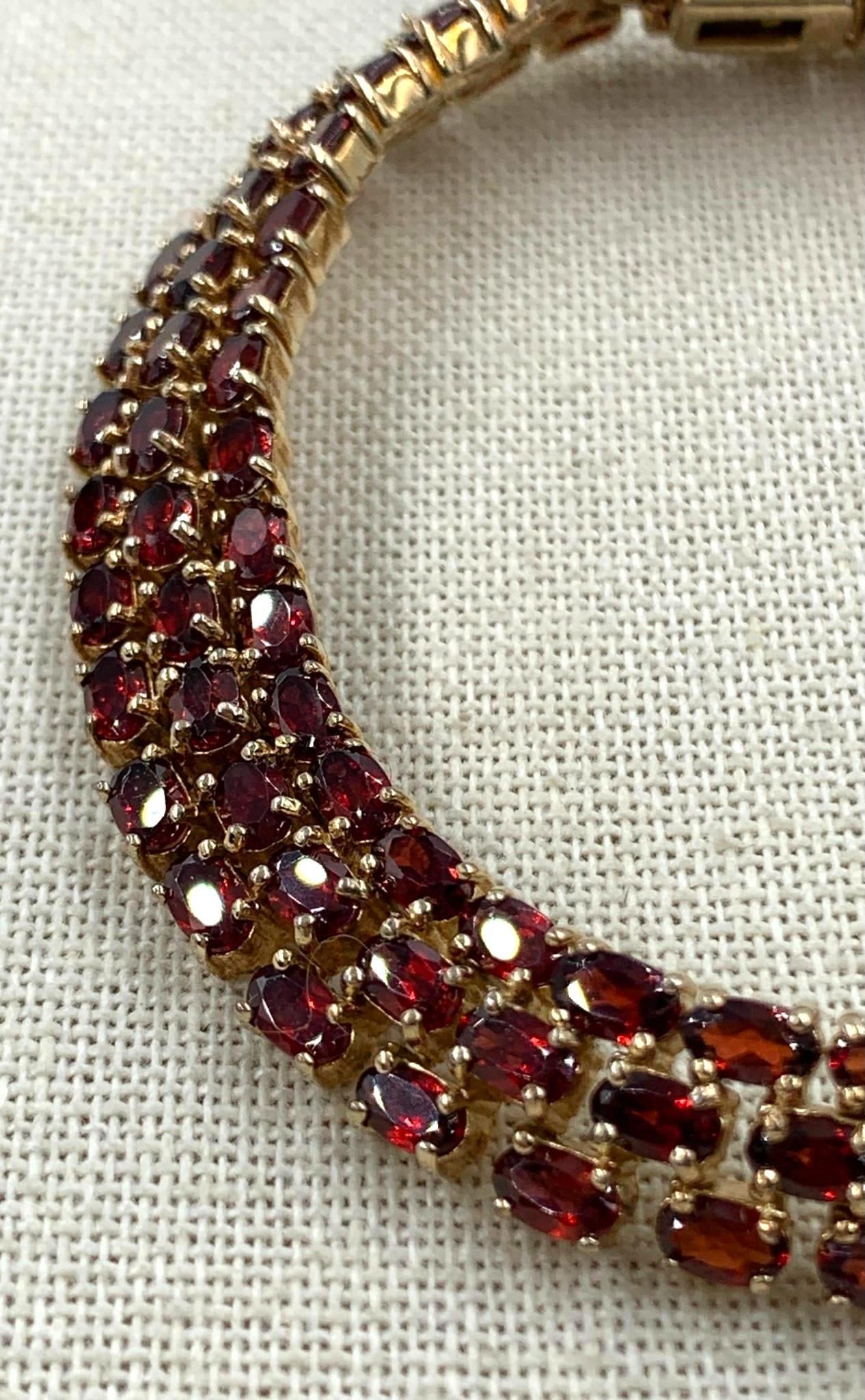 Opulent 29 CTW Garnet Gemstone Gold Vermeil over Sterling Silver Bracelet: 116 5x3mm (approx. .25 Carat per gemstone) prong set Garnet gemstones, 925 hallmark, 8 1/2" length, 37.25 gram weight, one gemstone with damage as shown, working closure and safety clasps, Beautiful r