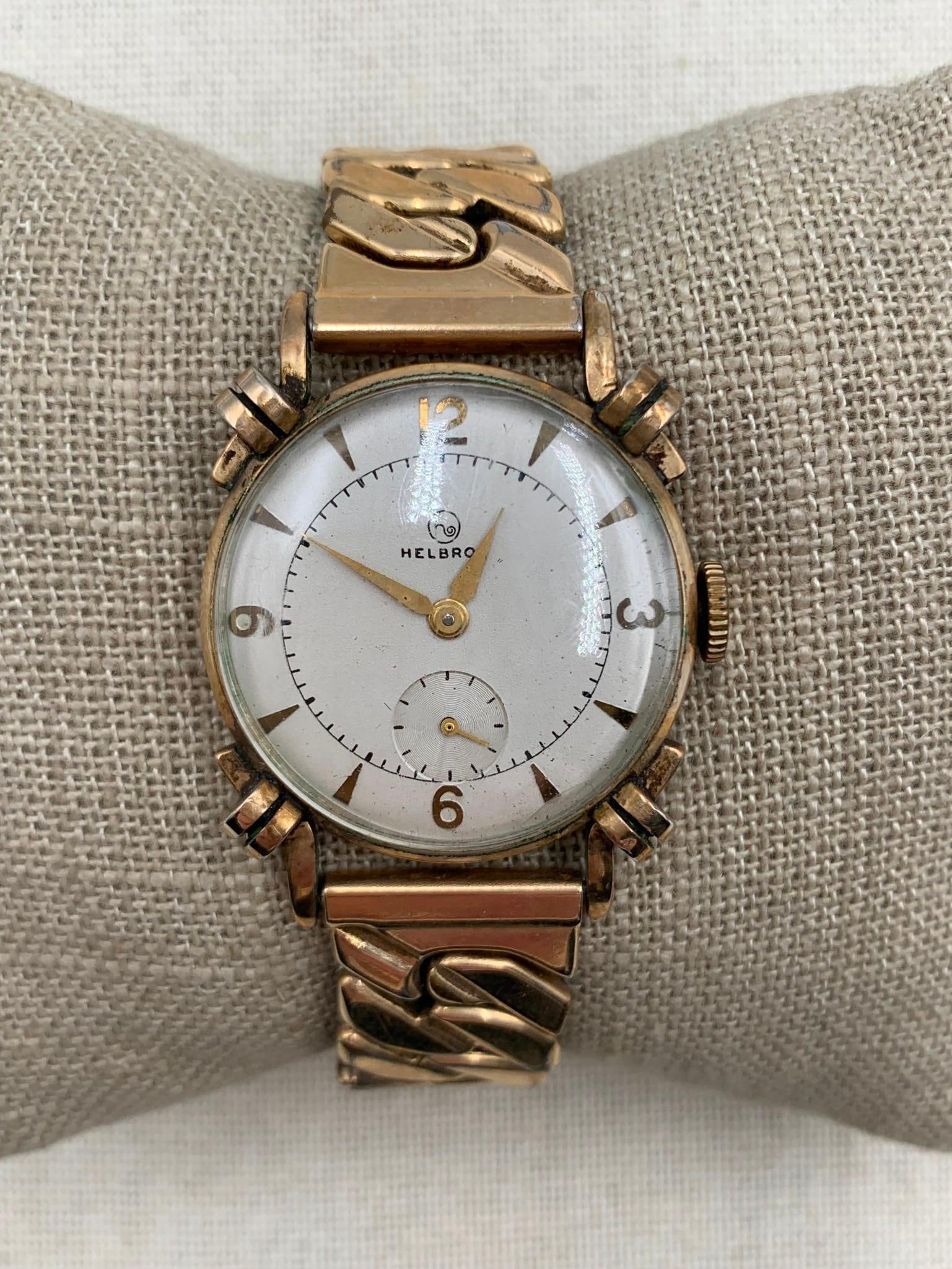 Working Mid Century HELBROS Men's 10k RGP Knotted Lug Mechanical Wristwatch: 1/20th 10k USA made flex band, 10k RGP bezel, Helbros logo, works when wound with sunken sub-seconds dial, surface wear to the convex crystal.