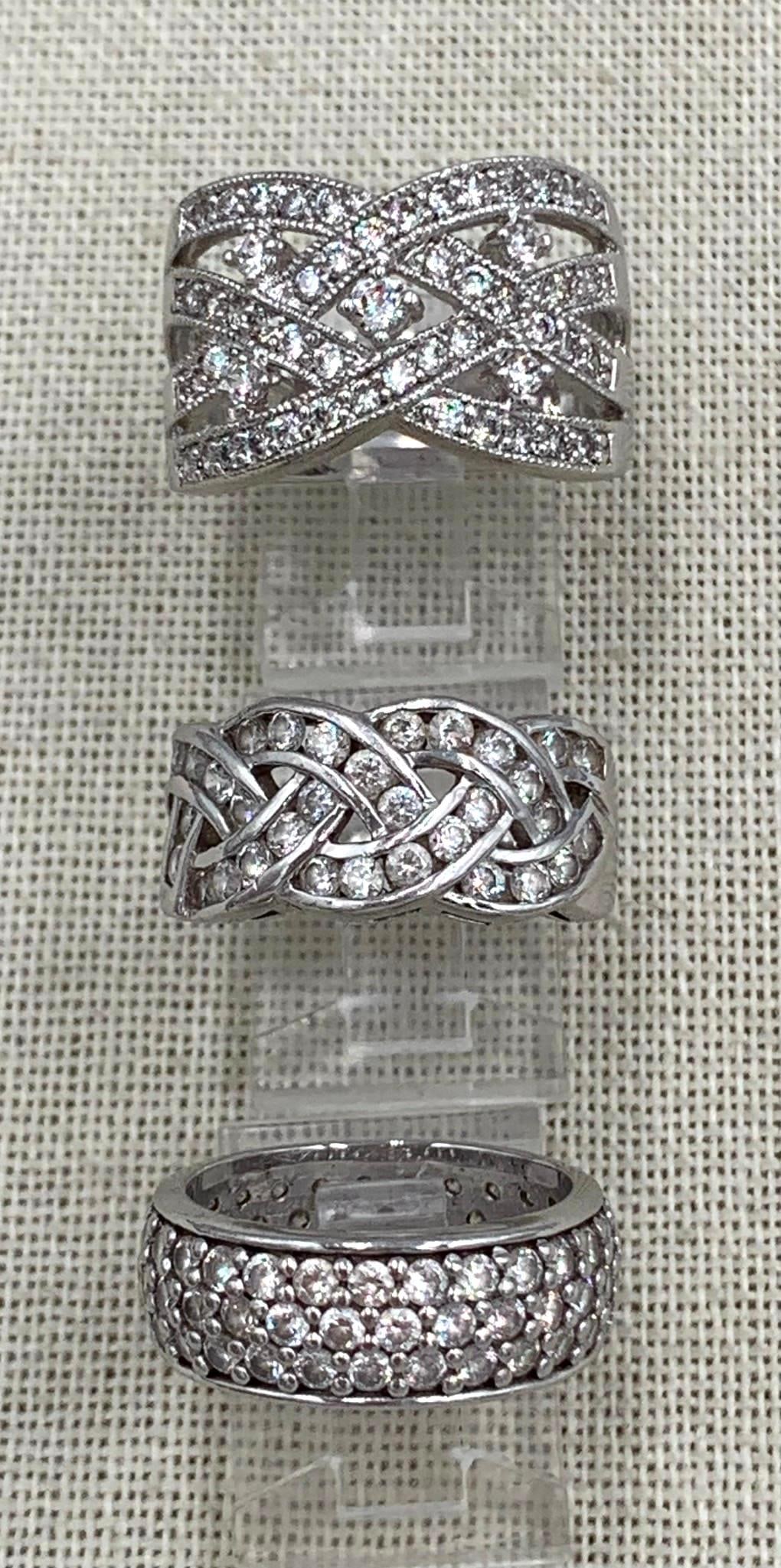 Trio of Decadent Sterling Silver Sparkling CZ Gemstone Rings: * 925 hallmark, size 10, woven openwork CZ cigar band, superb sparkle, 5/8in34; across the finger, 10.28 gram weight * 925 hallmark, domed pave CZ eternity band, 6.75 size, 5.52 gram weight * 925 hall