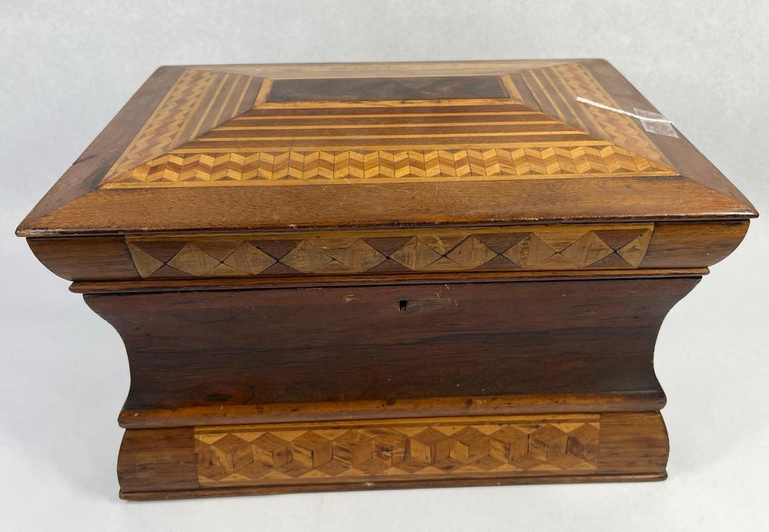 19th C. American Marquetry Workbox: 13x9x7.5 This 19th-century wooden workbox, attributed to American folk art traditions, features a sarcophagus form with a waisted profile and extensive parquetry and marquetry decoration throughout.