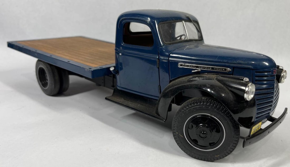 Attributed 1941 GMC Flatbed, Highway 61: 16 in. This scale model of a 1941 GMC flatbed truck is attributed to Highway 61 in 1/16 scale. The model is constructed from die-cast metal with plastic components and rubber-like tires. The cab and