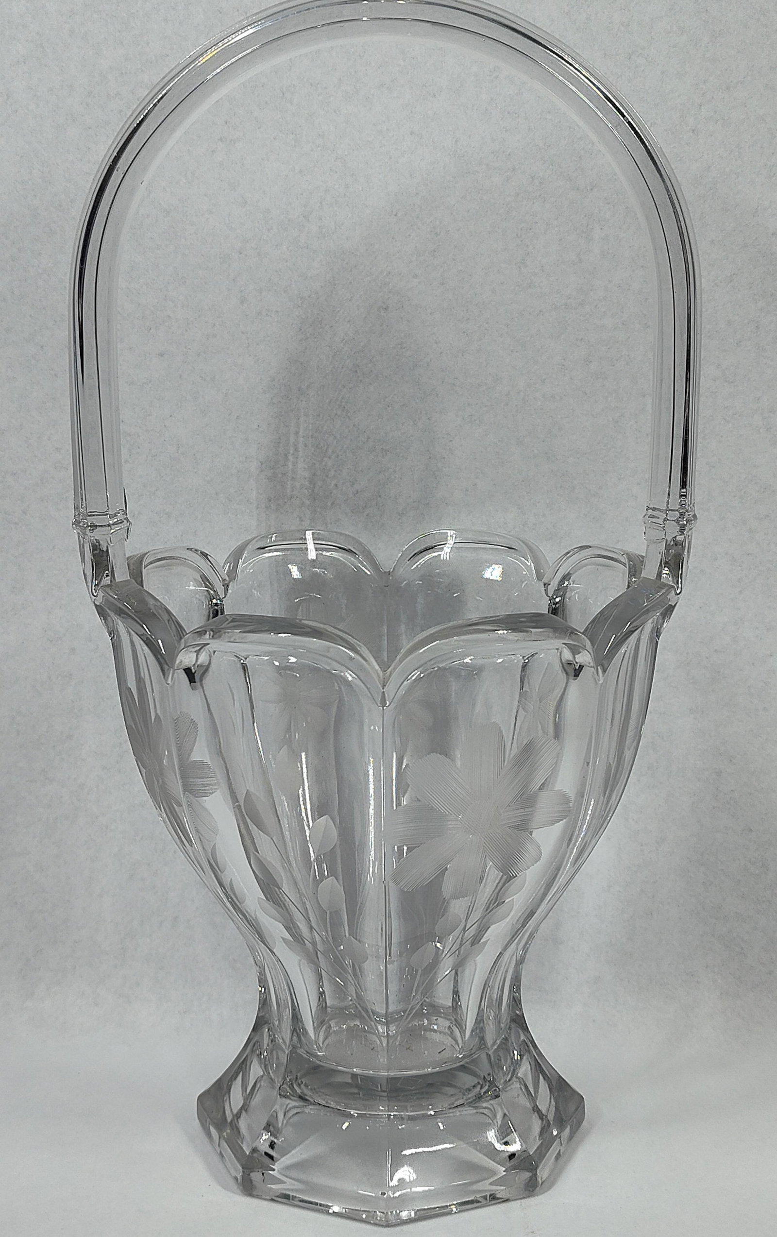 Heisey Colonial Floral Engraved Basket: 13 inches tall. A clear glass basket produced by A.H. Heisey and Company of Newark, Ohio. This piece is designed in the Colonial pattern, also known as No. 459, featuring wide vertical flutes and a