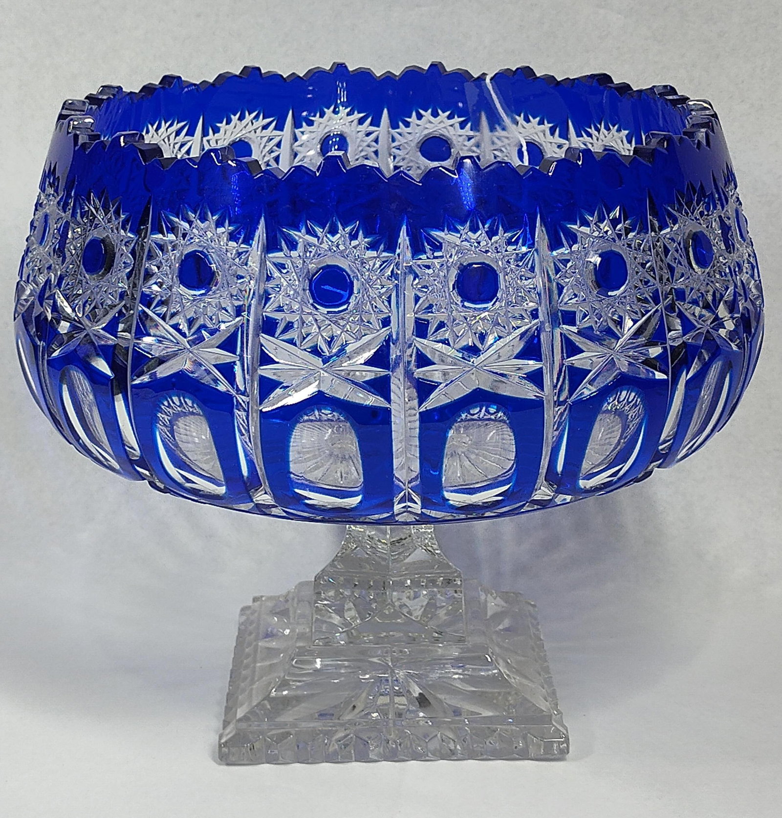 Faberge Cobalt Cut to Clear Center Bowl: 9x9 A large cobalt blue cut to clear cased crystal pedestal bowl or centerpiece. This piece features a rich layer of cobalt blue glass over a clear lead crystal core that has been hand-cut to create a