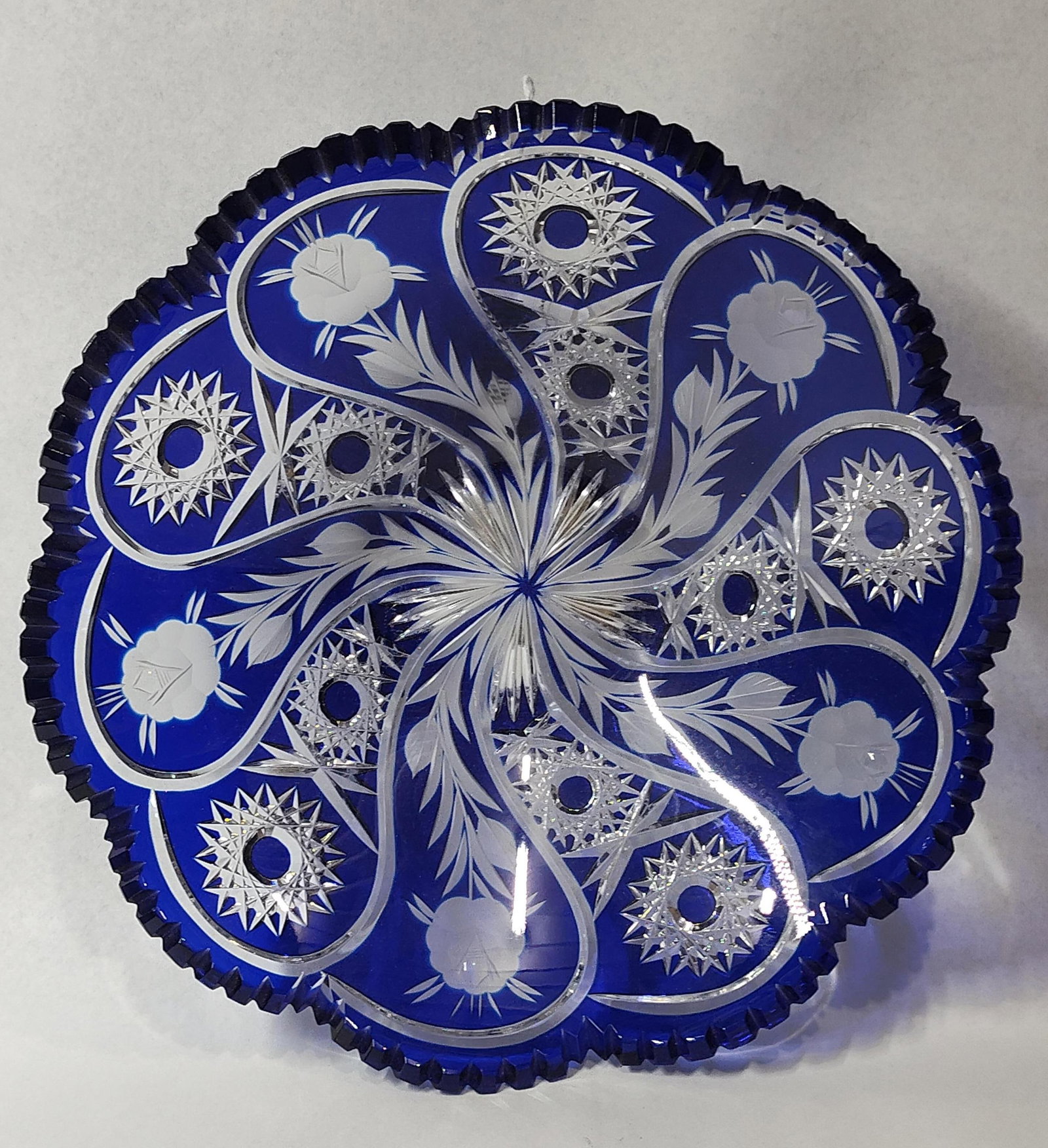 Bohemian Cobalt Cut to Clear Bowl: 11.5x3 A large circular centerpiece bowl or low compote crafted from cobalt blue cased glass cut to clear crystal. The piece features a vibrant cobalt blue exterior layer cut through to a clear lead