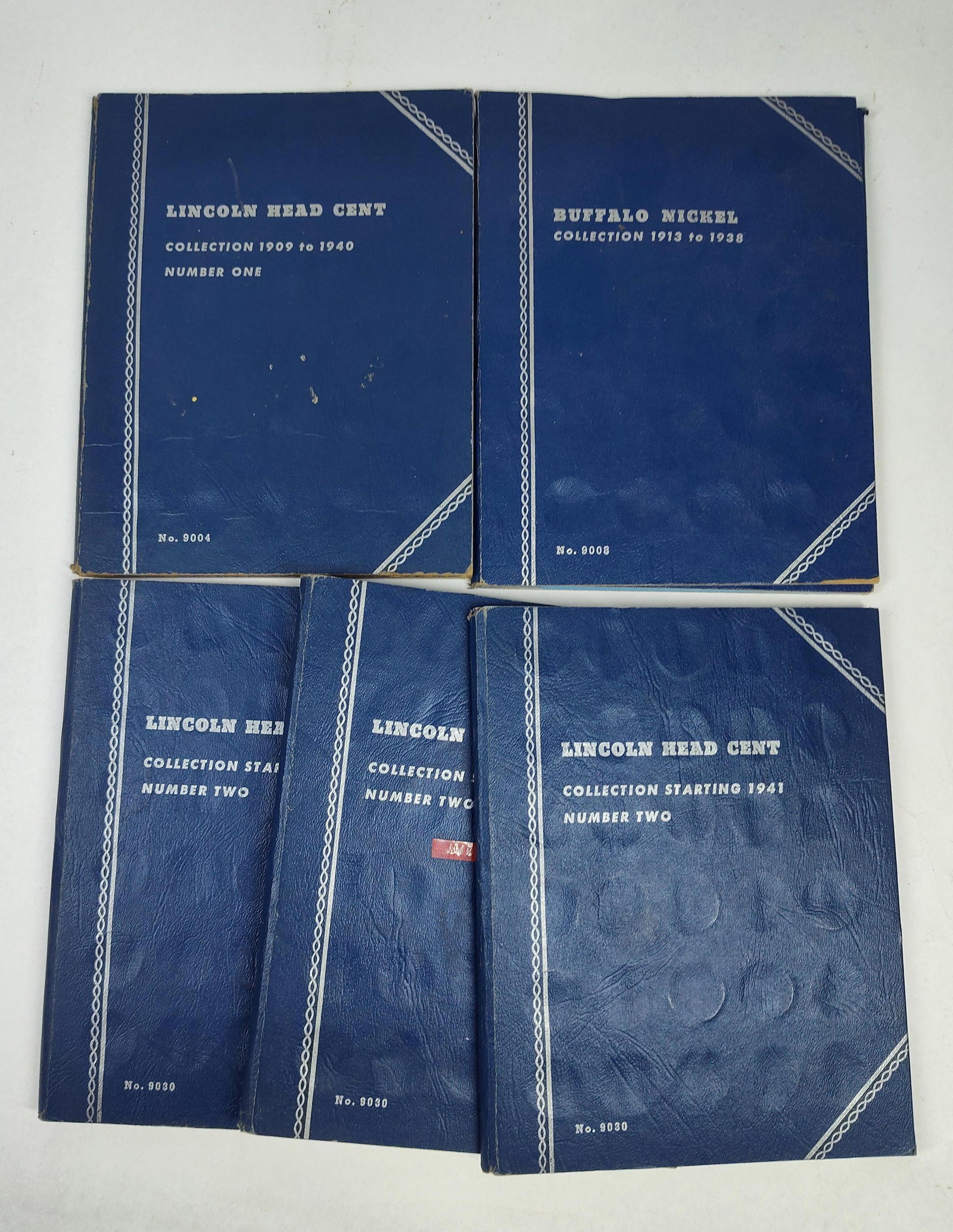US Lincoln Head Cents & Buffalo Nickels: A collection of United States coinage presented in five blue Whitman-brand coin folders. The assembly includes one folder for Lincoln Head Cents dated 1909 to 1940 (No. 9004), one folder for Buffalo