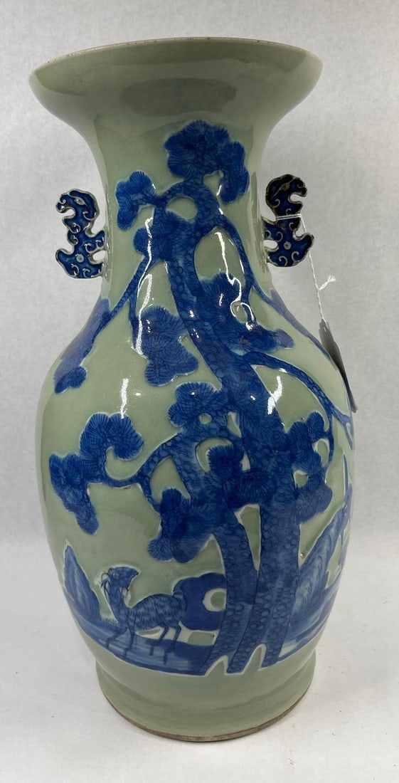 Chinese Relief Landscape Celadon Vase: 17X8. Handle Repaired. A Chinese porcelain vase of baluster form featuring a flared trumpet mouth and two applied stylized handles on the neck. The exterior is finished with a pale celadon-green groun