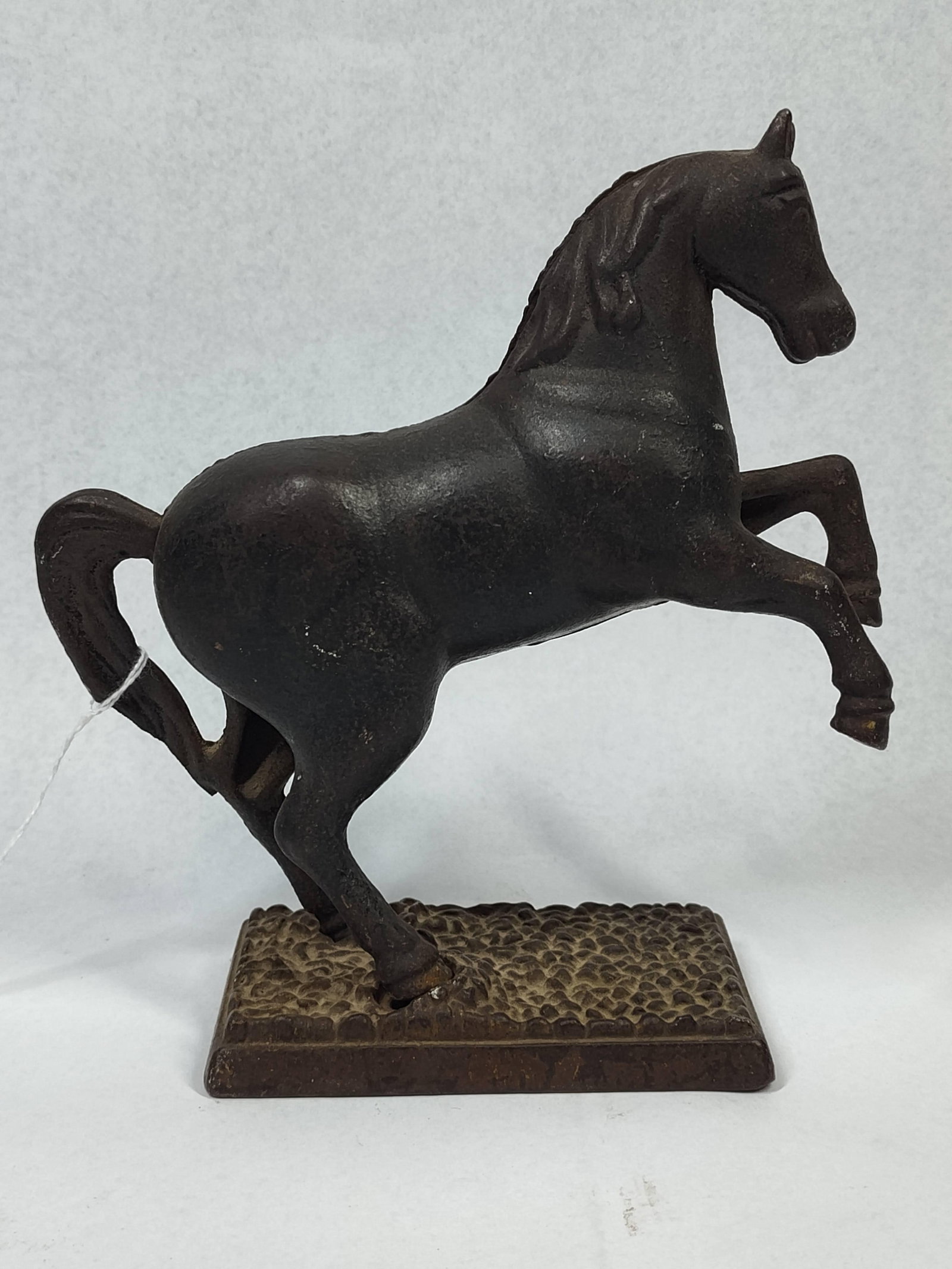 Rearing Horse Still Bank: 7x7 A still bank modeled in the form of a rearing horse, featuring a molded mane and tail. The item is manufactured from cast iron and consists of two separate halves joined by a single large