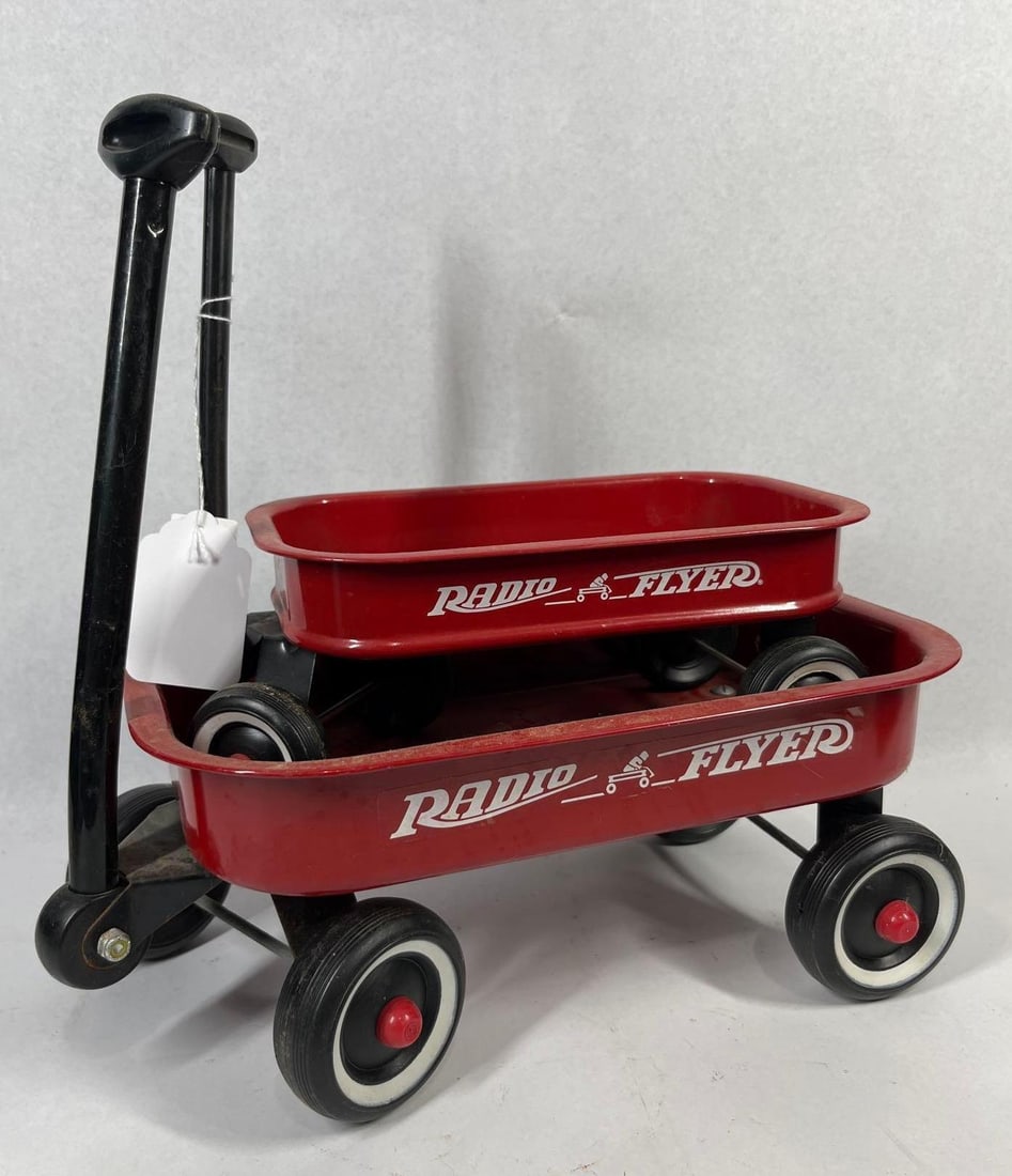Pair Radio Flyer Miniature Pull Wagons: 12.5x9.5 in long. This lot consists of two miniature collectible pull wagons manufactured by Radio Flyer. Both items are constructed with painted red pressed steel bodies and feature black plastic