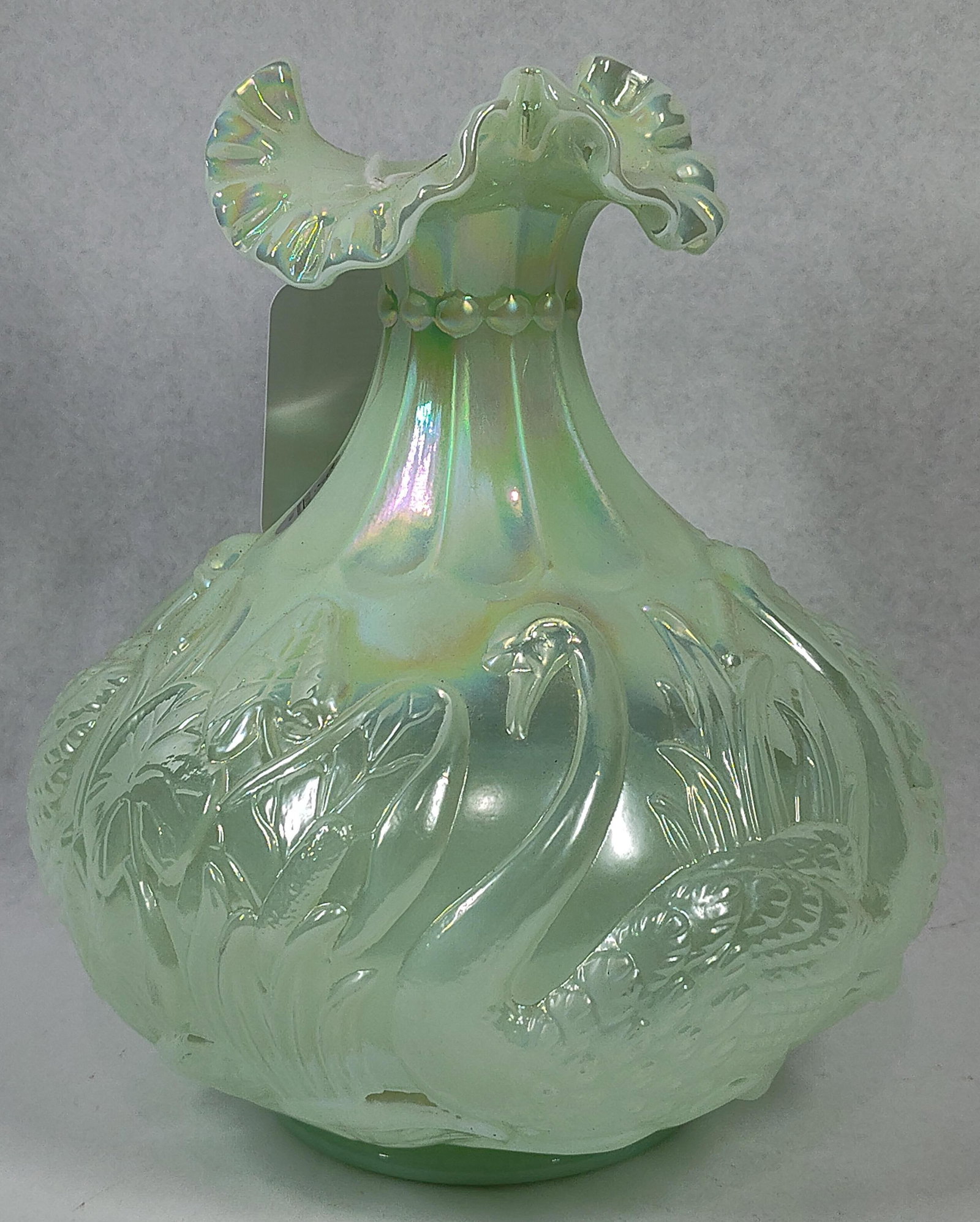 George Fenton Fenton Iridized Swan Vase: 7.5 in tall. A Fenton Art Glass bulbous vase featuring the Swans pattern, part of the 1998 Historic Collection. The piece is crafted from Sea Green opalescent glass with a lustrous iridescent finish.