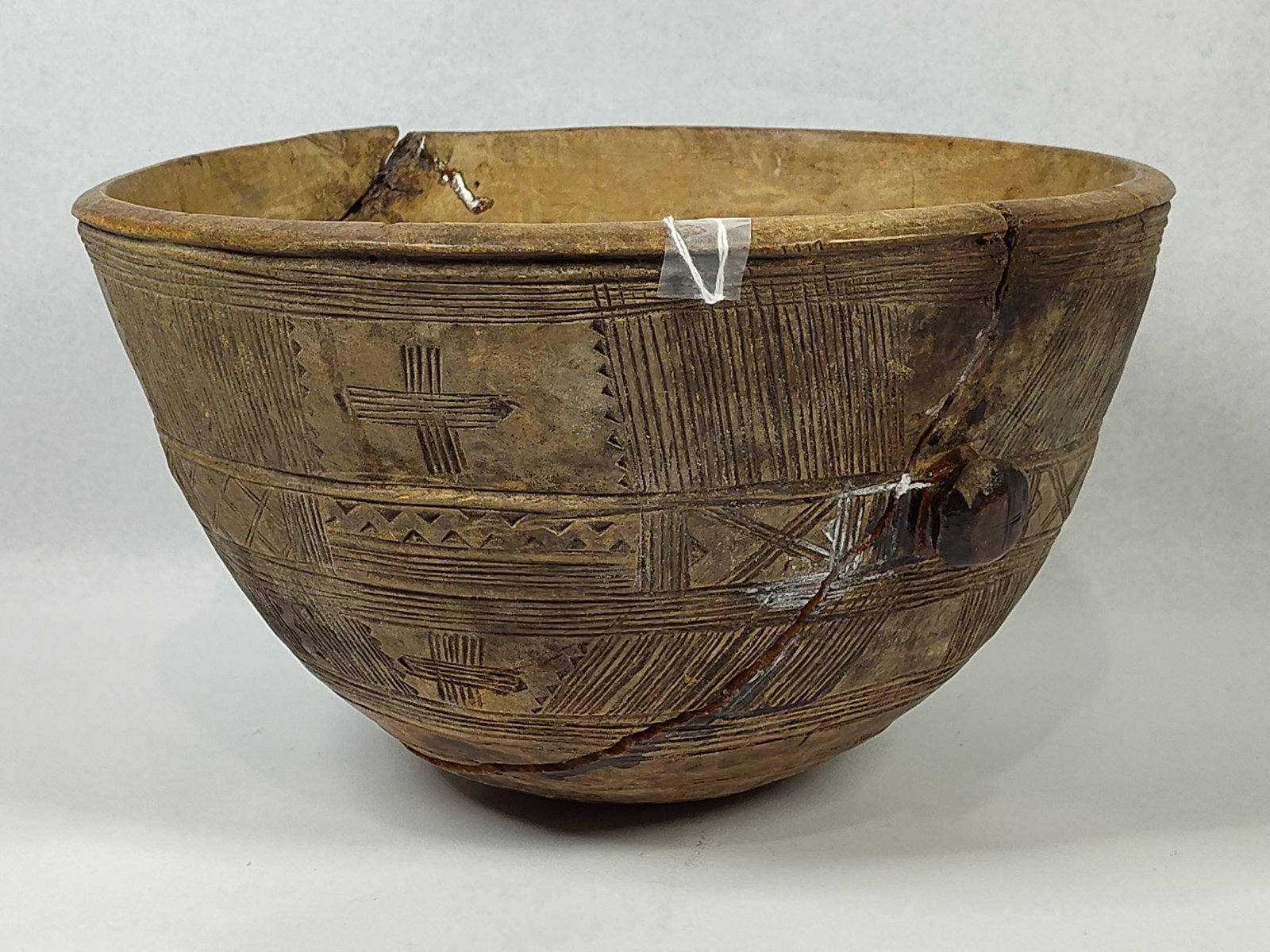 Tuareg Incised Wooden Milk Bowl, Niger: 12x7.5. Large cracks and repairs. A hand-carved hardwood vessel attributed to the Tuareg or Hausa people of Niger. The bowl is of deep hemispherical form with a slightly thickened rim. The exterior su