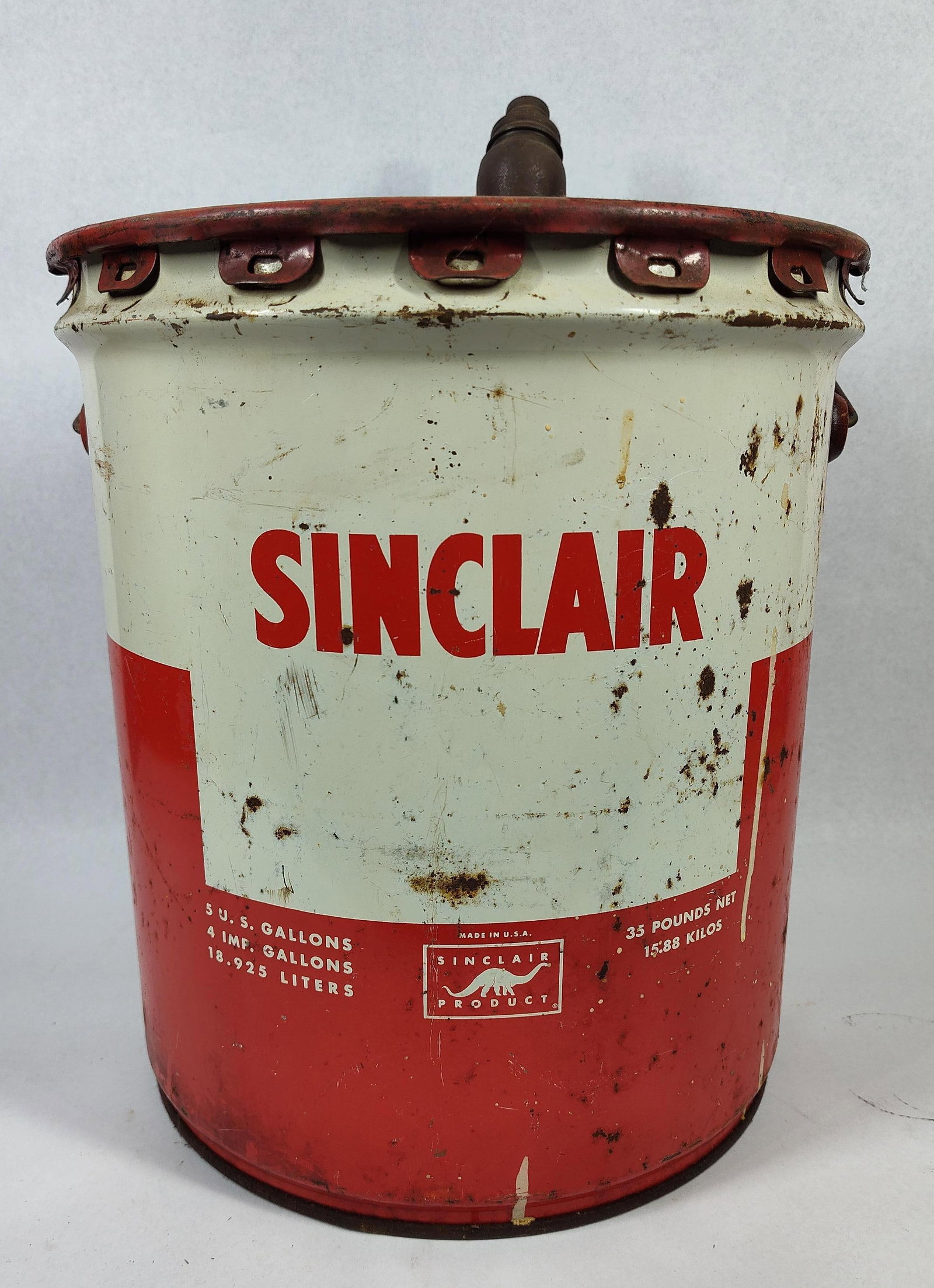 Sinclair Motor Oil Can w/ Pour Spout: A vintage 5-gallon bulk lubricant can produced for the Sinclair Refining Company. The container is constructed of lithographed steel featuring the brand's signature red and white color scheme. The