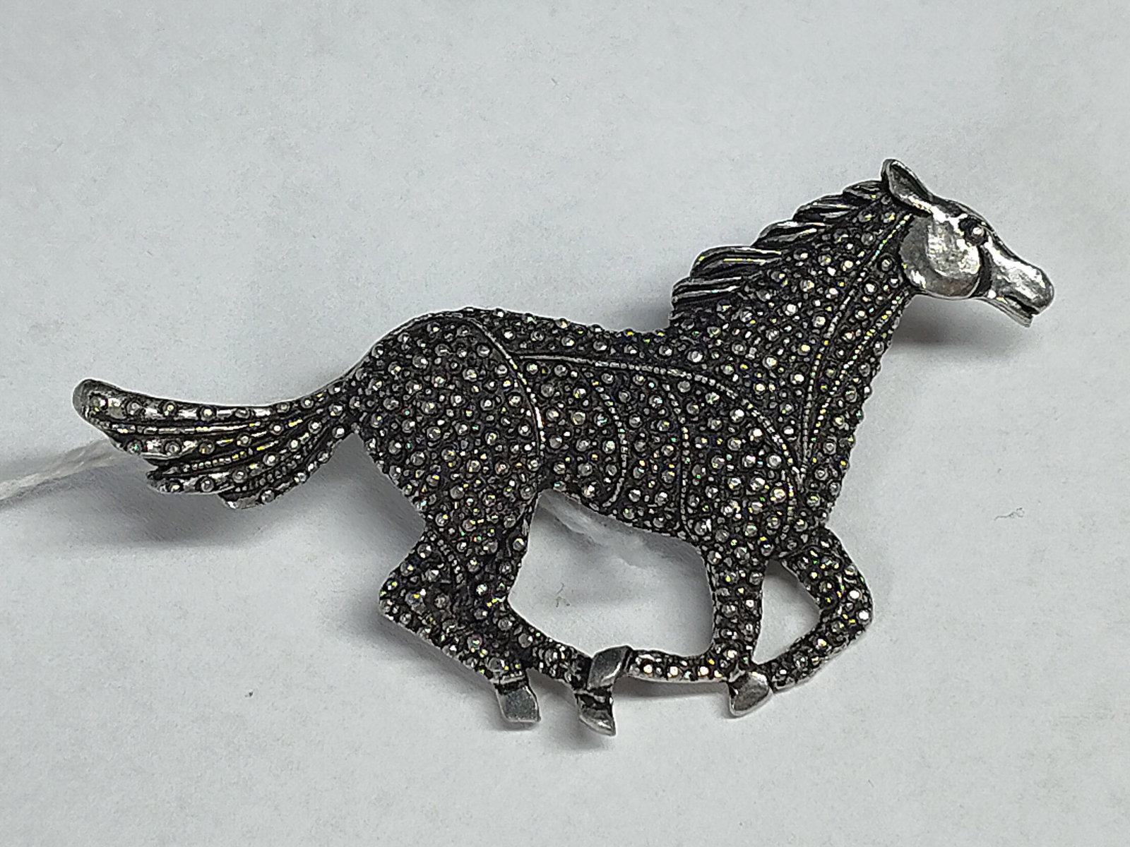 Seagull Pewter Sid Bell Horse Brooch: A figural brooch by Seagull Pewter featuring a galloping horse motif designed by Sid Bell. The piece is crafted from fine pewter with a silver-toned finish. The body, mane, and tail of the horse are