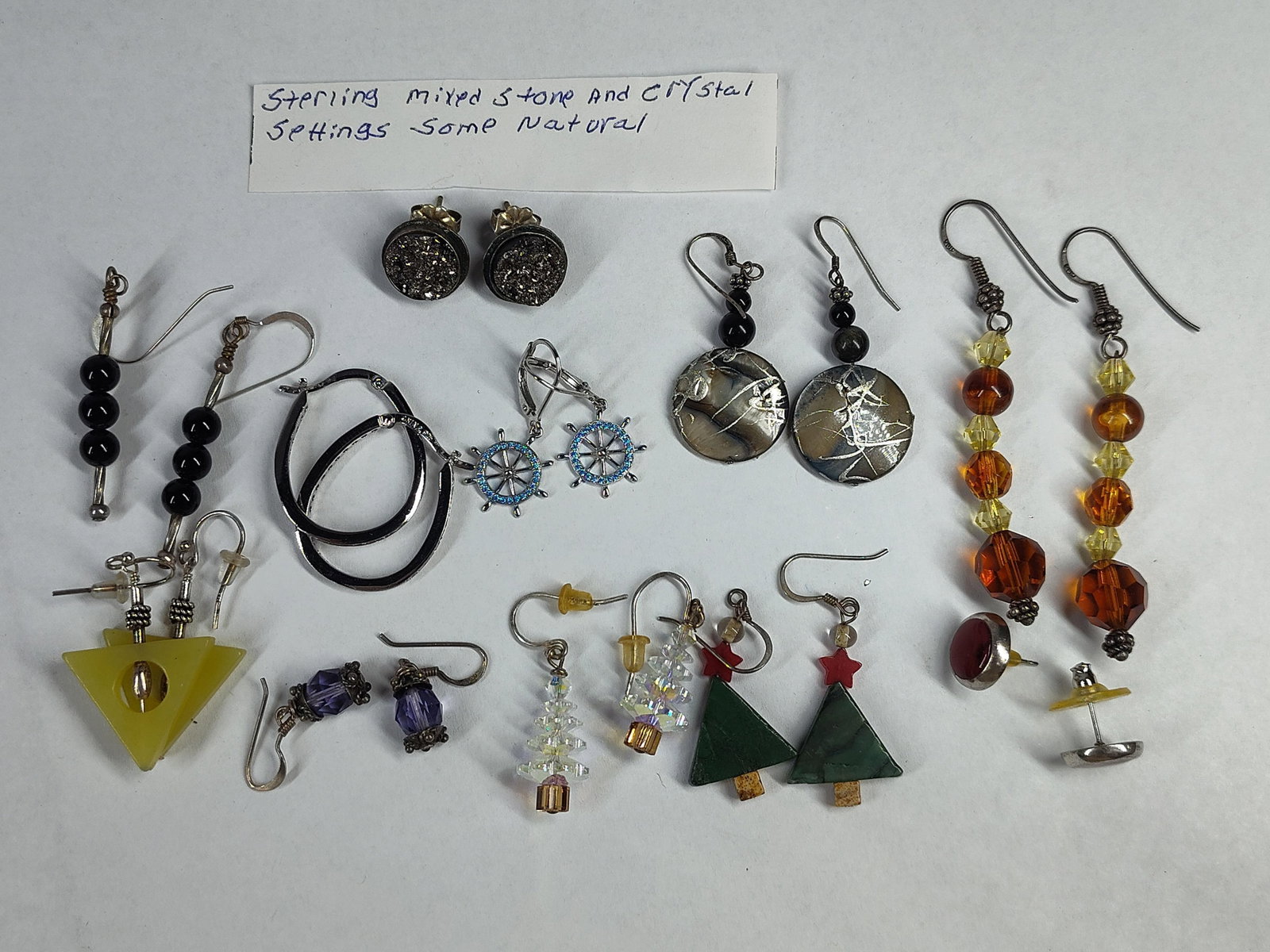 Str. Mixed Stone & Crystal Earrings: This collection comprises various styles of pierced earrings featuring sterling silver, mixed natural stones, and crystal accents. Key pieces include a pair of oval sterling silver hoops channel-set