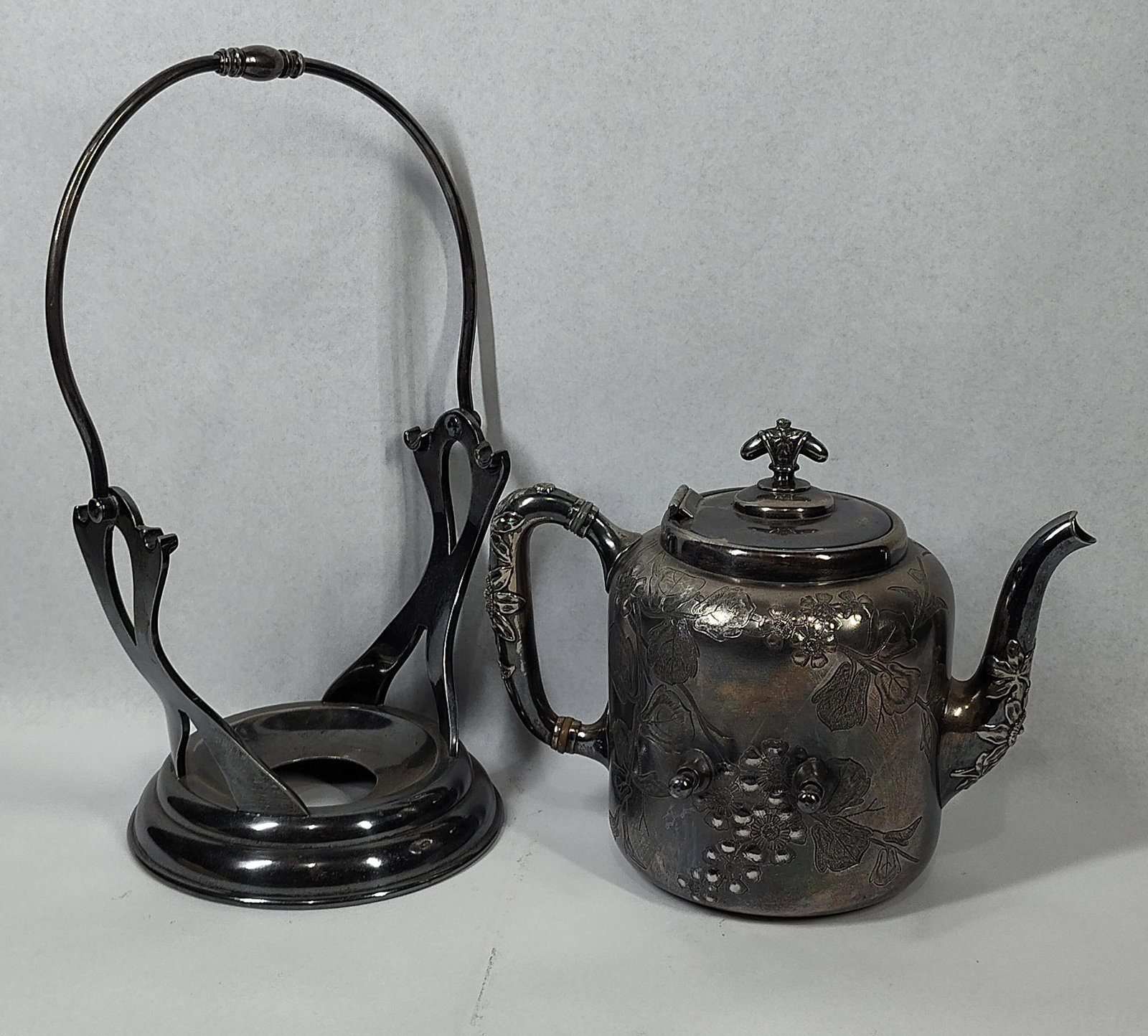 Meriden Silver Plate Co. Tilting Teapot: 10 in tall. A Victorian-era silver-plated tilting teapot, also known as a kettle-on-stand, manufactured by the Meriden Silver Plate Co. of Meriden, Connecticut. The set consists of a cylindrical