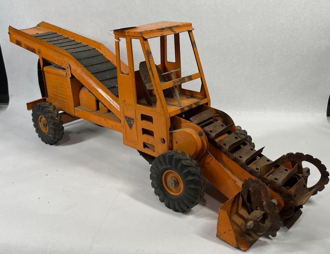 Nylint Adams TraveLoader Steel Toy: 30 in long This vintage Nylint Adams TraveLoader is a licensed scale model of the industrial self-propelled windrow loader authorized by the J.D. Adams Manufacturing Company. The toy is constructed
