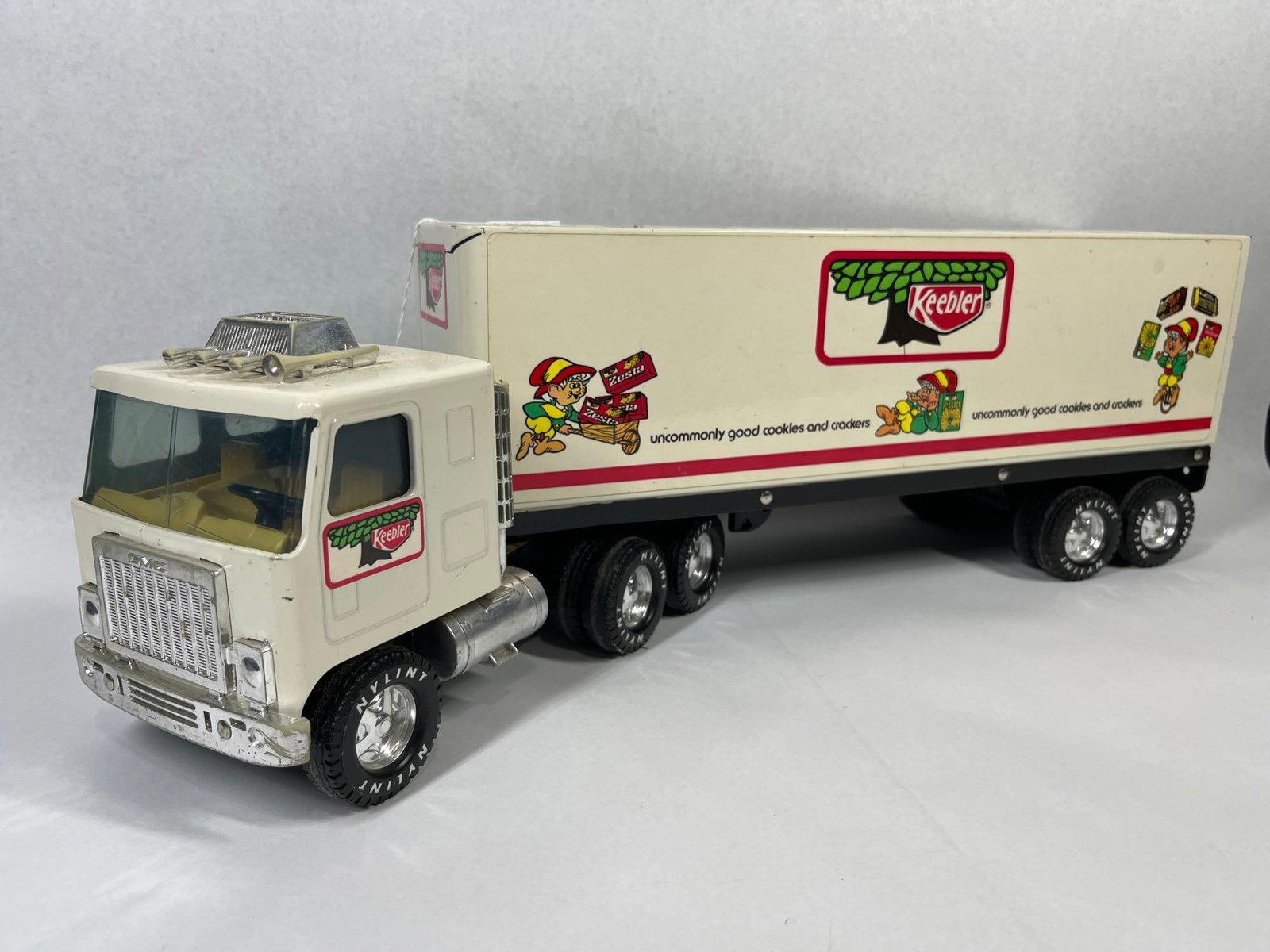 Nylint GMC Astro 95 Keebler Semi-Truck: 21 in. A vintage Nylint Corporation pressed steel semi-truck and trailer featuring Keebler advertising livery. The tractor unit is a GMC Astro 95 cab-over-engine model. The cab and trailer body are
