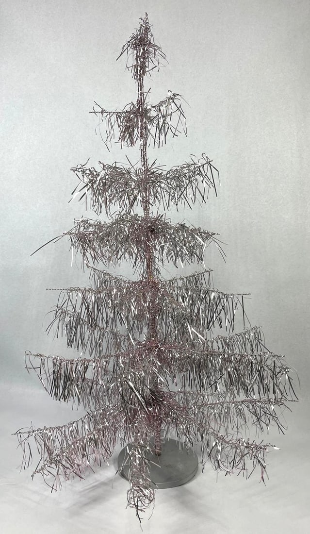 Bethany Lowe Attr. Pink Icicle Tree: 32 in tall. This tabletop holiday tree is attributed to Bethany Lowe Designs, identified as the Icicle Shiny Trim Tree model. The decorative item features a rose-pink or pink aluminum-colored