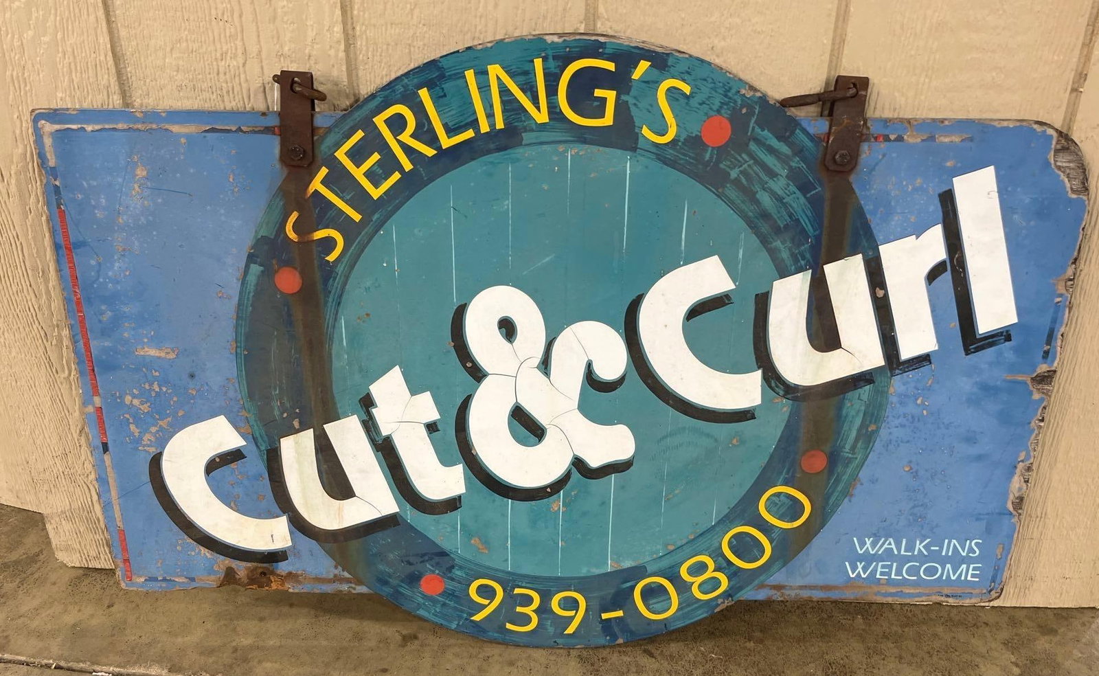 Mid-20th C. Sterling's Cut & Curl Sign: 36x24 in. Wood painted. This large vintage commercial advertising sign is constructed from a rectangular metal panel and was designed for a hair salon. The sign features a weathered blue background wi