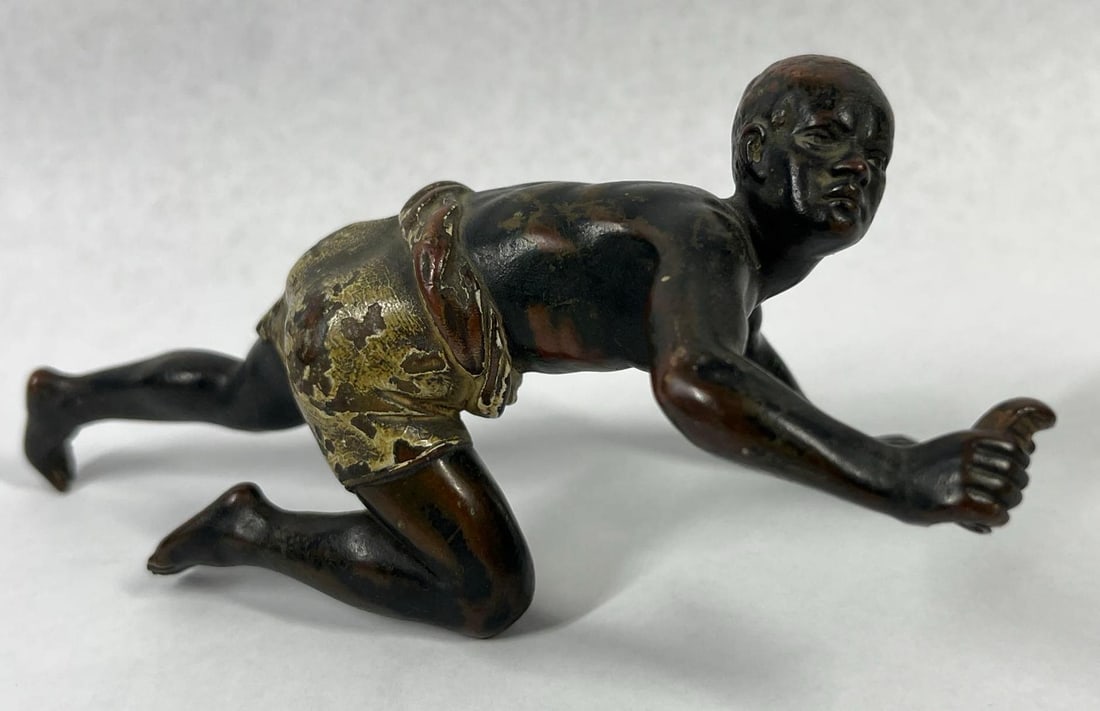 Bergman Style Cold-Painted Bronze Boy: 6x3x2.5 This hollow-cast bronze figure is rendered in the late 19th to early 20th-century Austrian style associated with the Franz Bergman foundry. The sculpture depicts a young male of African descen
