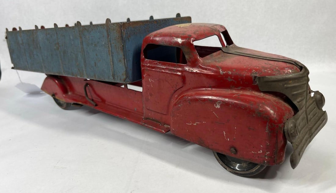 Vintage Streamline Era Toy Dump Truck: 21 inches. This toy is a large-scale dump truck featuring a streamline Art Deco aesthetic. Based on the distinctive horizontal-slatted front grille with integrated headlights and the specific cab